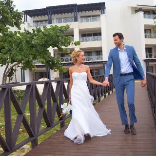 The bride and groom walking across a wooden bridge at Royalton Negril, Negril