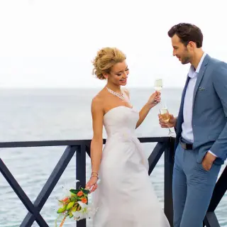 Bride and groom toasting with champagne on a terrace at Royalton Negril