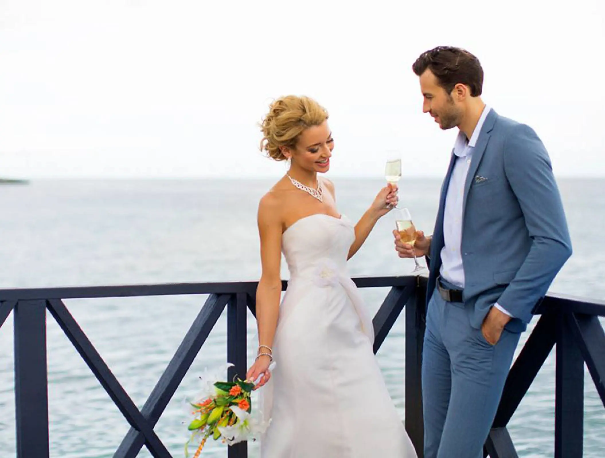 Bride and groom toasting with champagne on a terrace at Royalton Negril