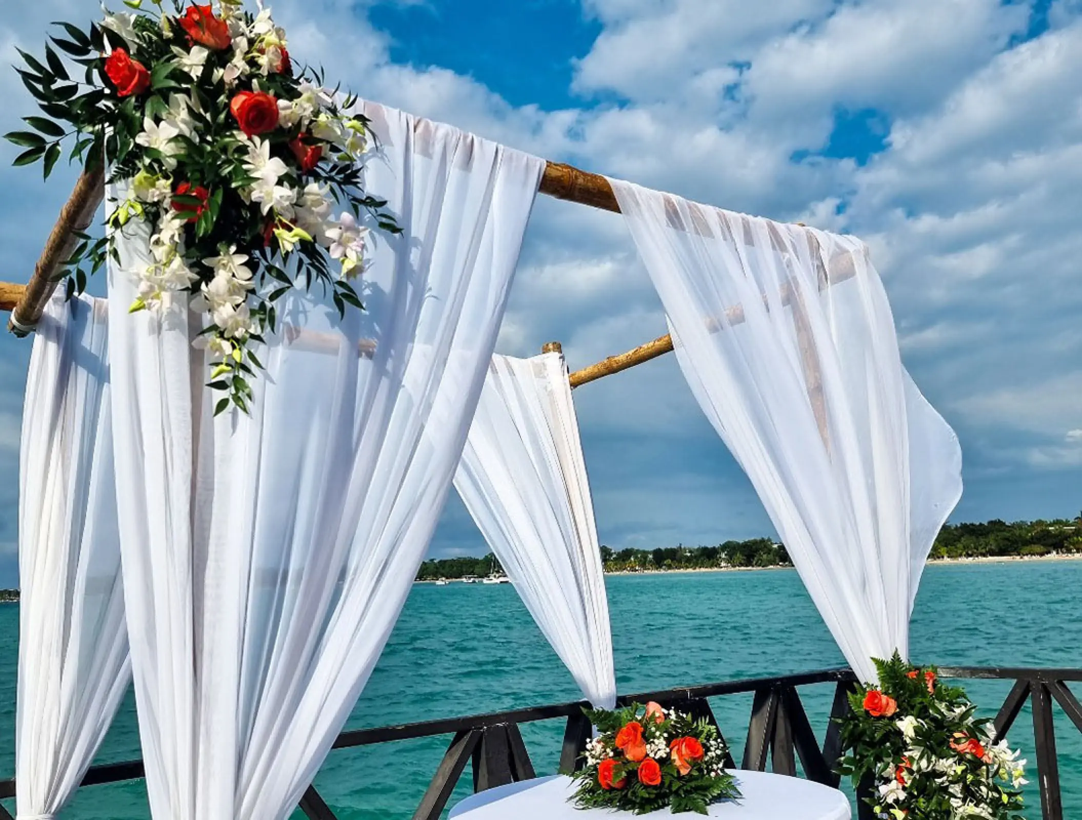 Wedding ceremony huppah with white draping and tropical flowers at Royalton Hideaway Negril, Jamaica