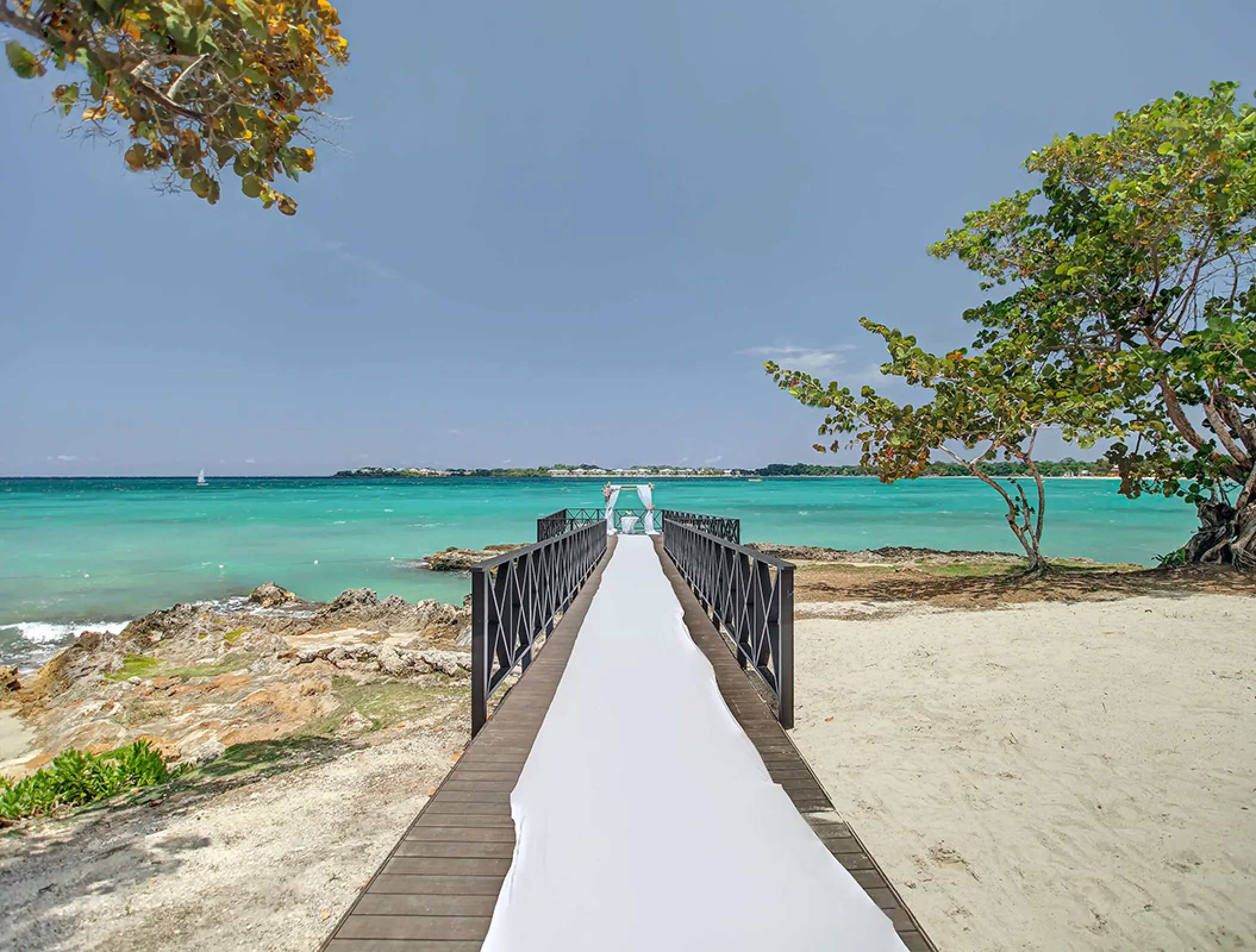 Oceanfront wedding ceremony pier with white runner at Royalton Negril, Negril