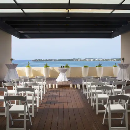 Sky terrace wedding ceremony setup with white chairs at Royalton Negril