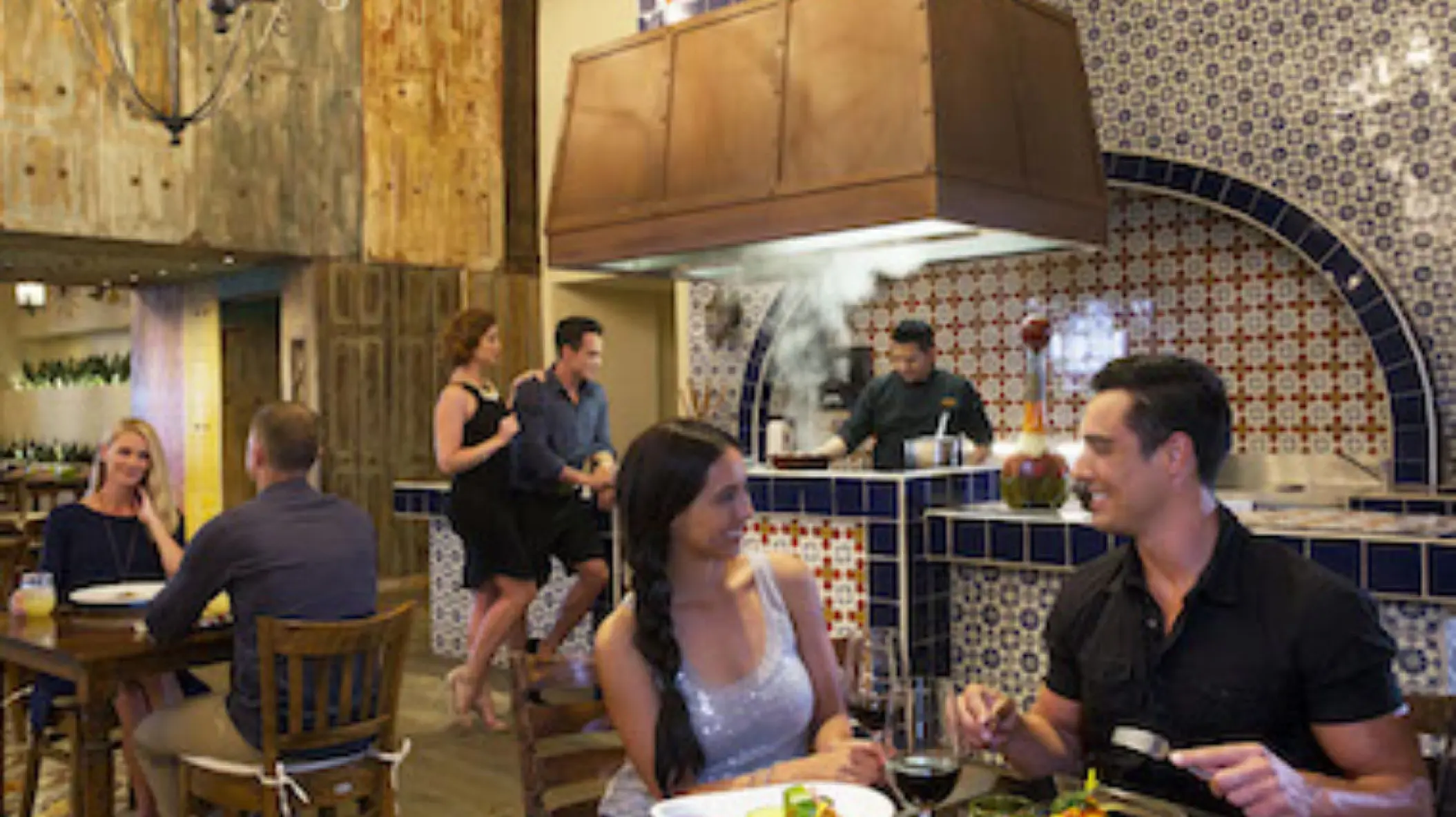Couples dining at a tiled restaurant with an open kitchen at Royalton Riviera Cancun