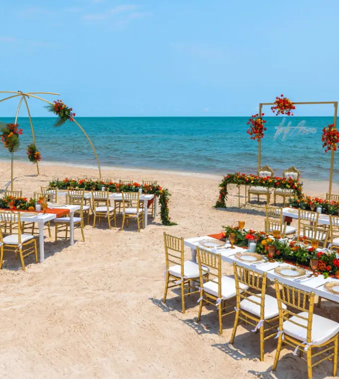 Beach wedding reception with gold chairs and floral runners at Royalton Splash Riviera Cancun, Cancun