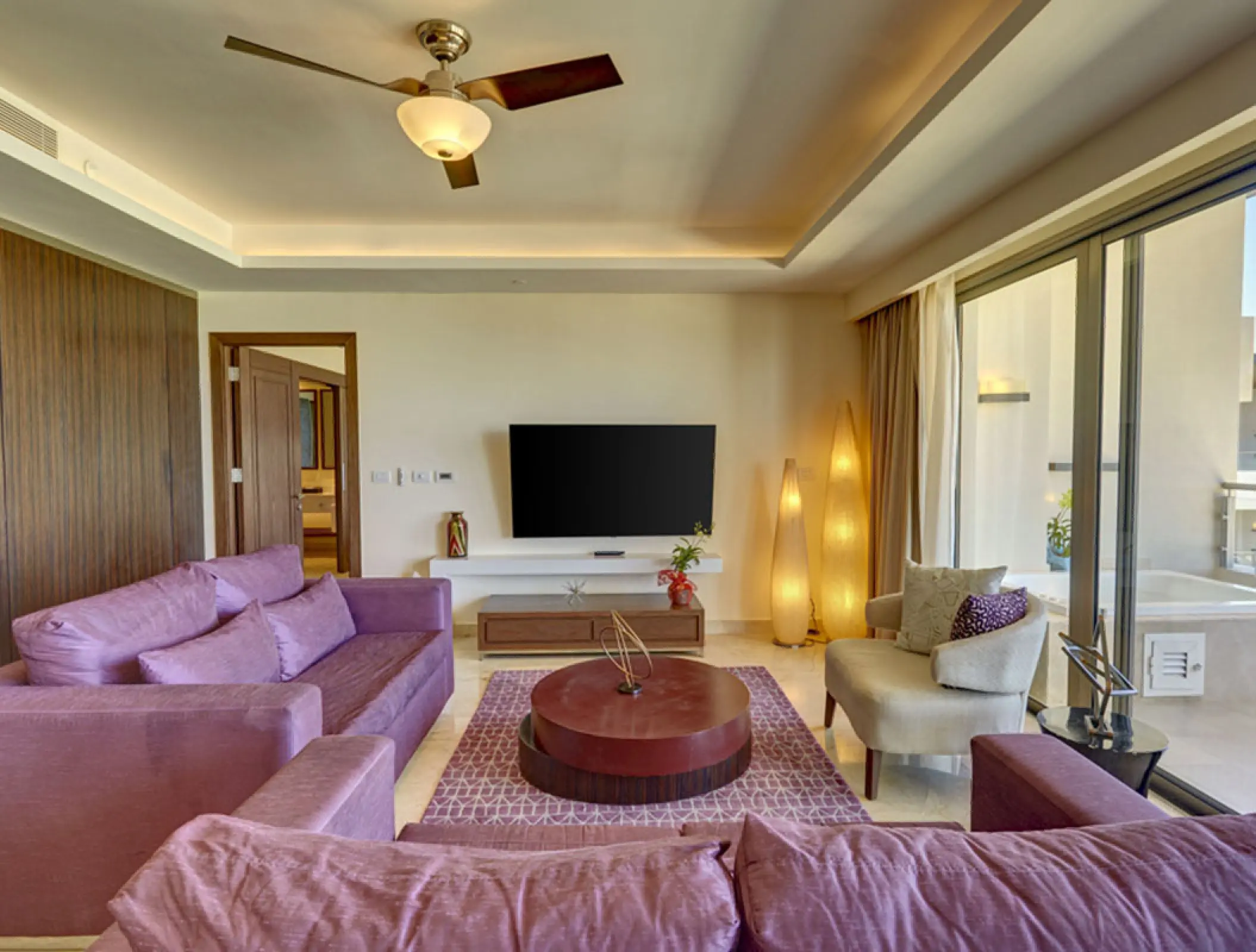 Chairman Suite living room with purple sofas and a balcony at Royalton Blue Waters, Montego Bay