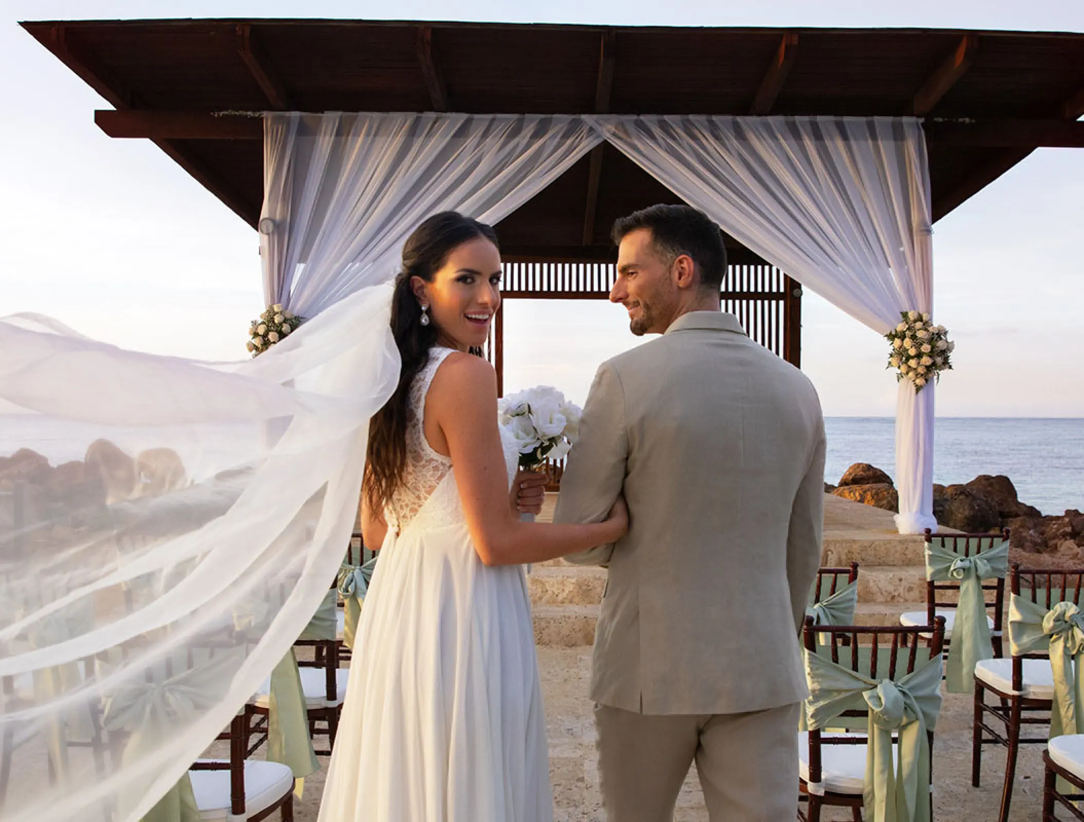 Bride and groom standing at an oceanfront wedding ceremony gazebo at Royalton Blue Waters, Montego Bay