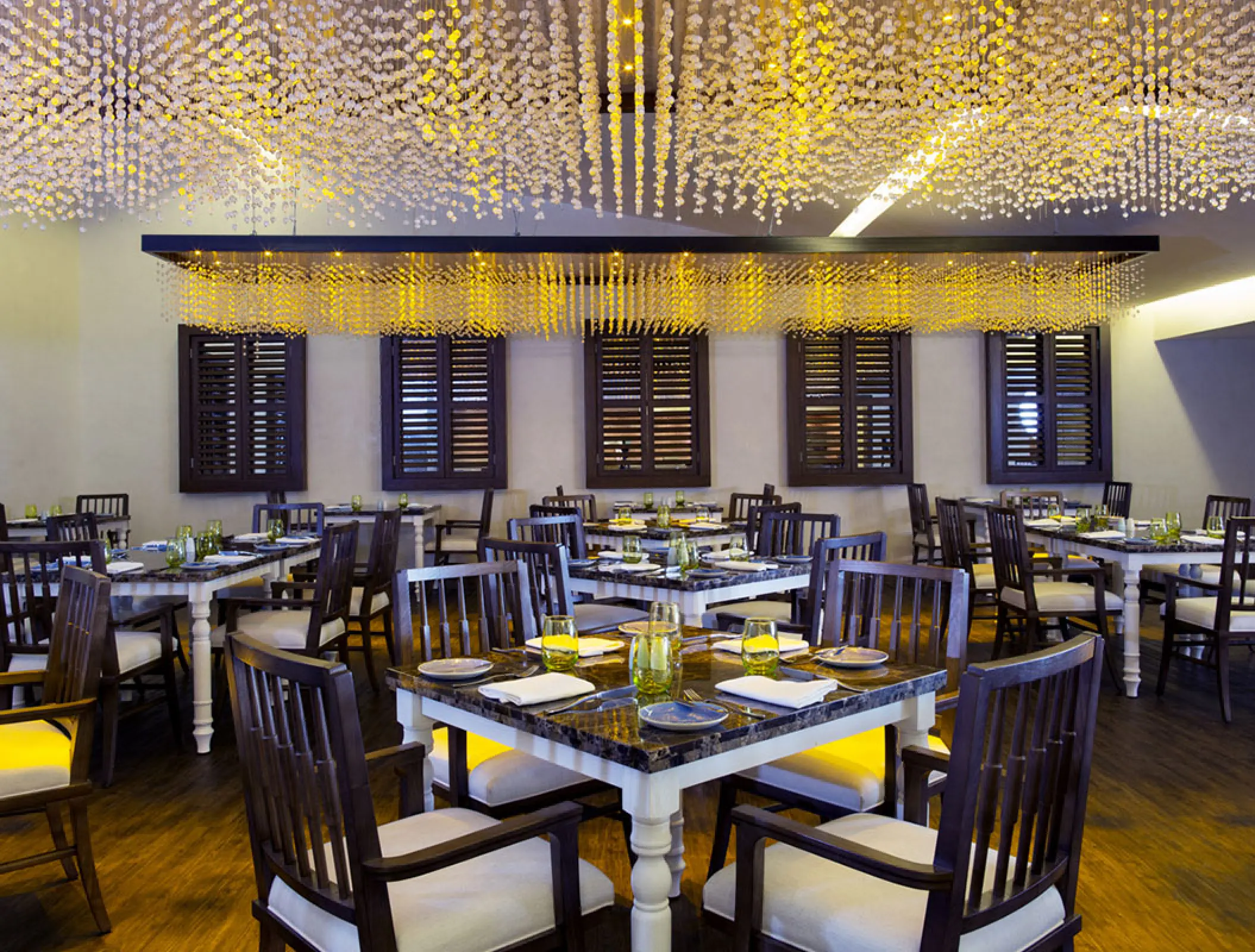 Indoor restaurant dining area with crystal chandeliers at Royalton Blue Waters, Montego Bay