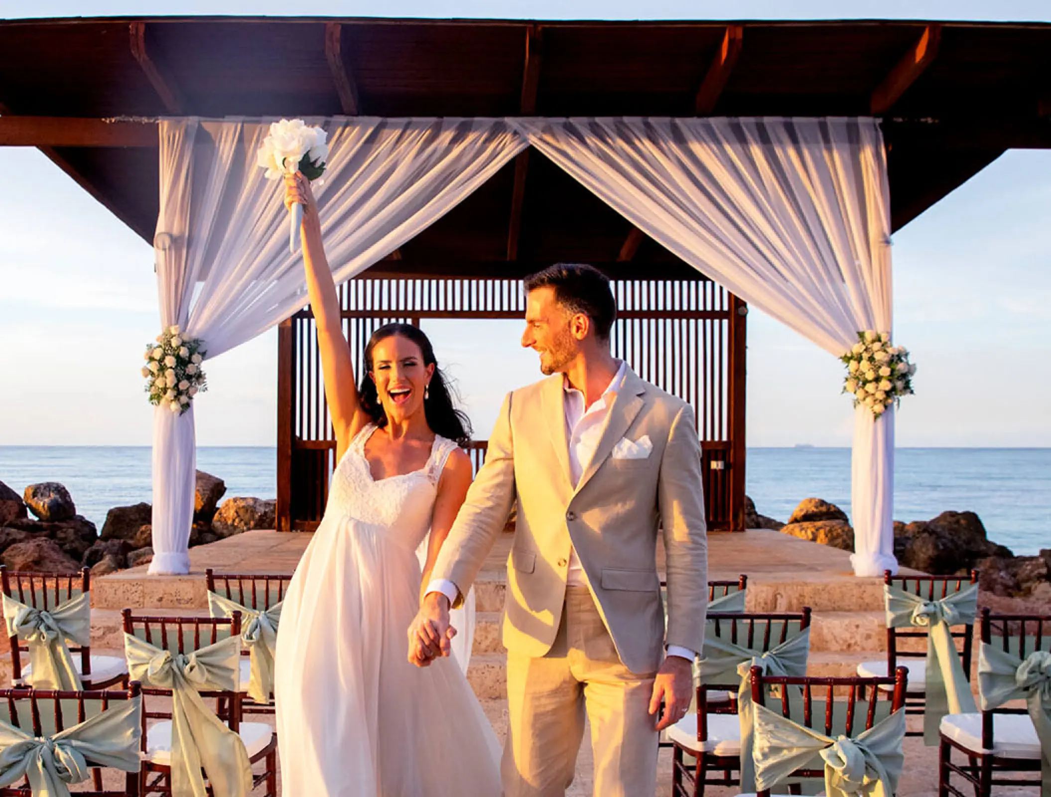 Newlywed couple celebrating at their beach ceremony at Royalton Blue Waters, Montego Bay