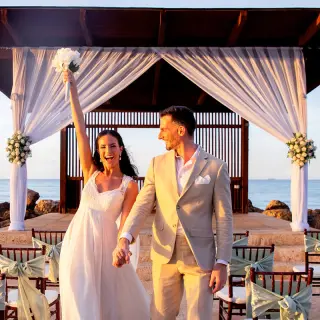 The bride and groom celebrate at their oceanfront wedding ceremony at Royalton Blue Waters, Montego Bay