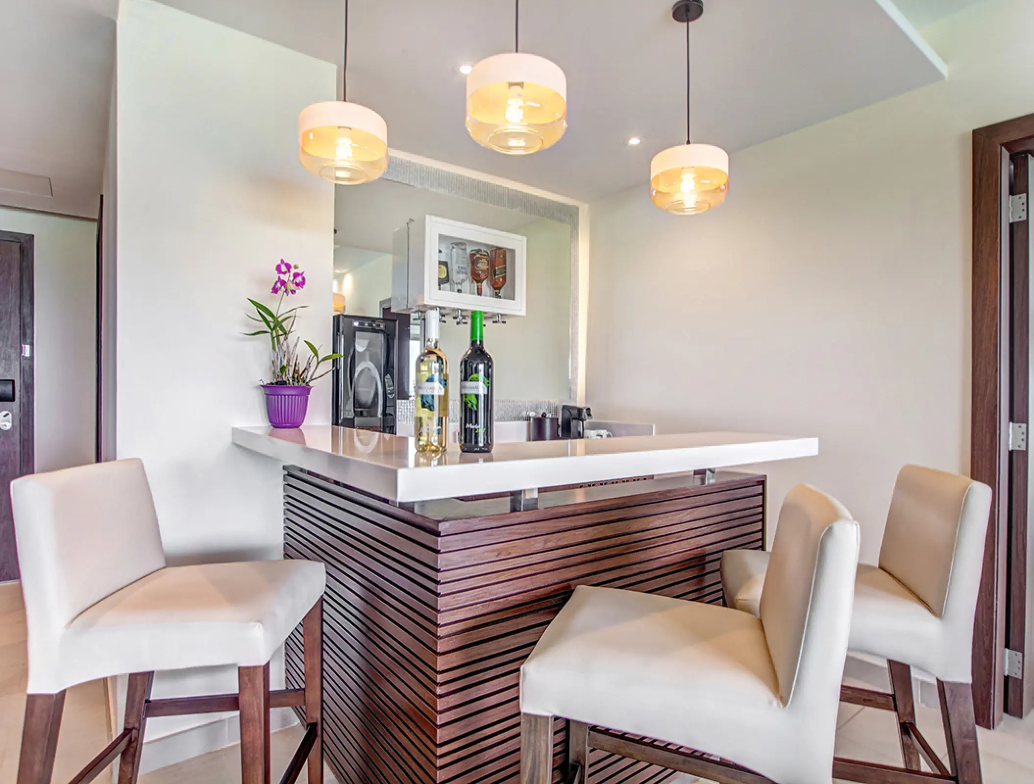Luxury Presidential Suite bar with white seating and wine bottles at Royalton Negril, Negril