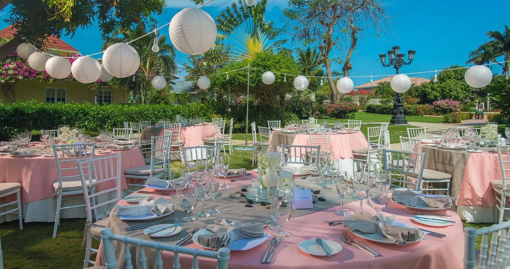 Outdoor wedding reception with pink linens and paper lanterns at Sandals Montego Bay, Jamaica