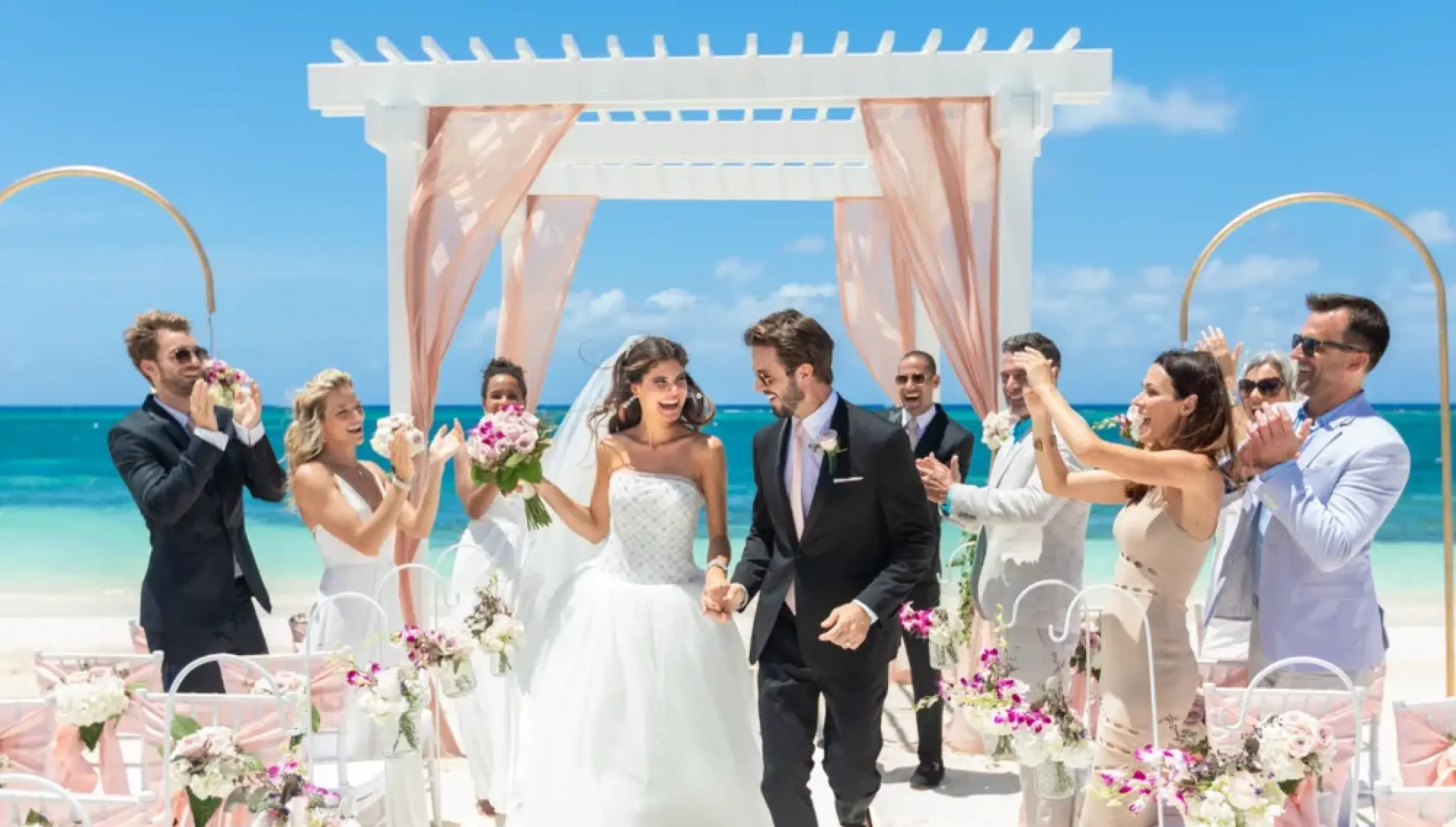 Newlyweds walking down the aisle at a beachfront wedding ceremony at Sandals Montego Bay, Jamaica