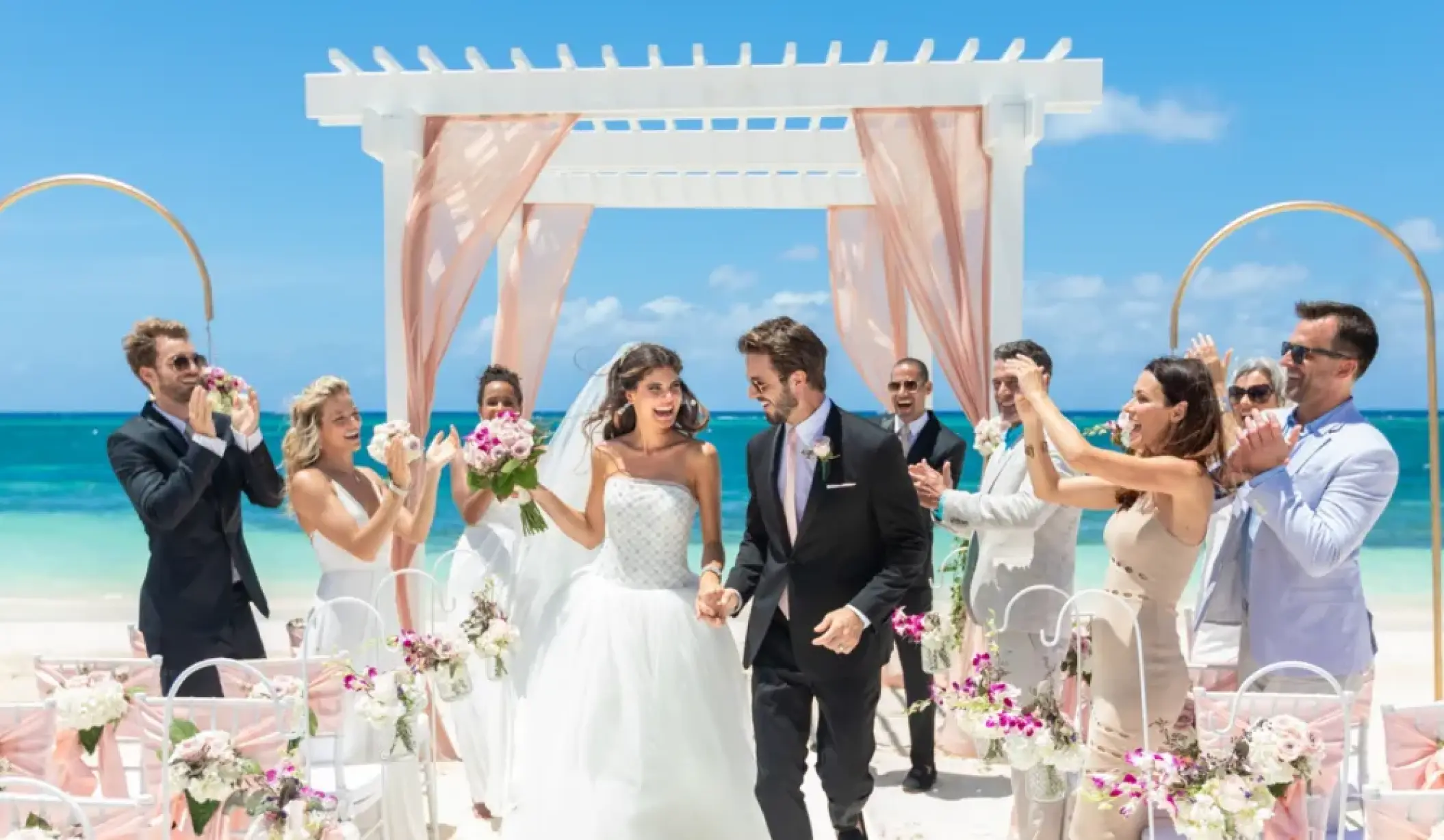Newlyweds walking down the aisle at a beachfront wedding ceremony at Sandals Montego Bay, Jamaica