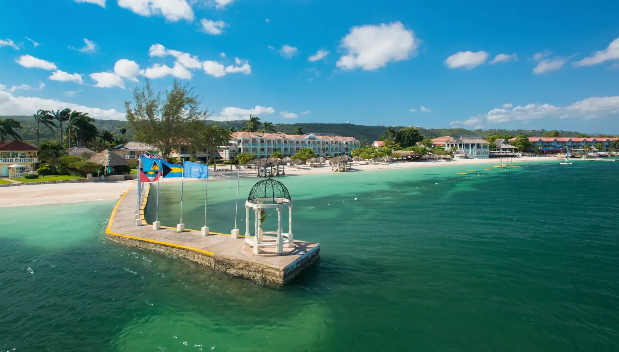 Greek wedding gazebo on a pier overlooking turquoise water at Sandals Montego Bay