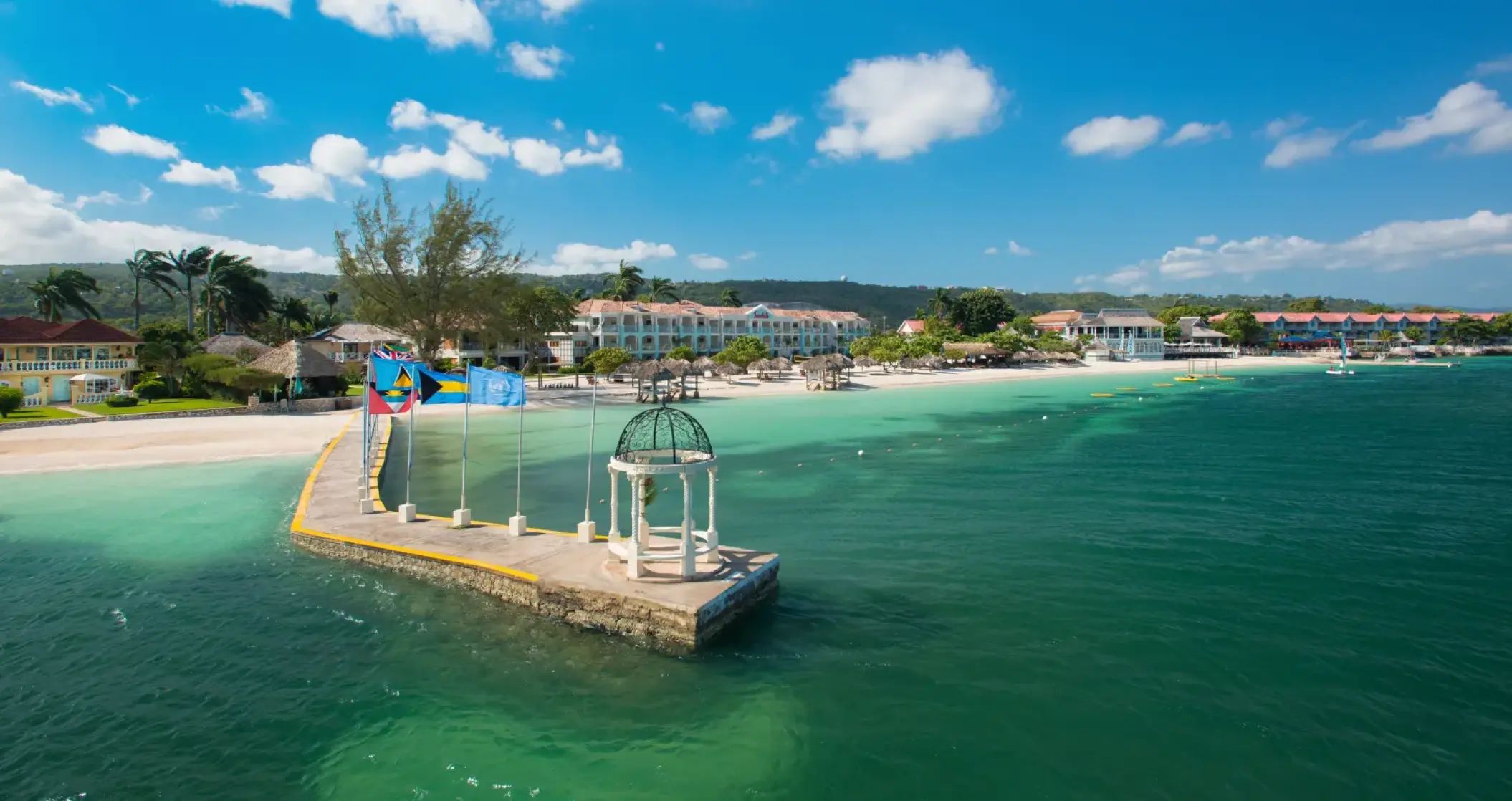 Greek wedding gazebo on a pier overlooking turquoise water at Sandals Montego Bay