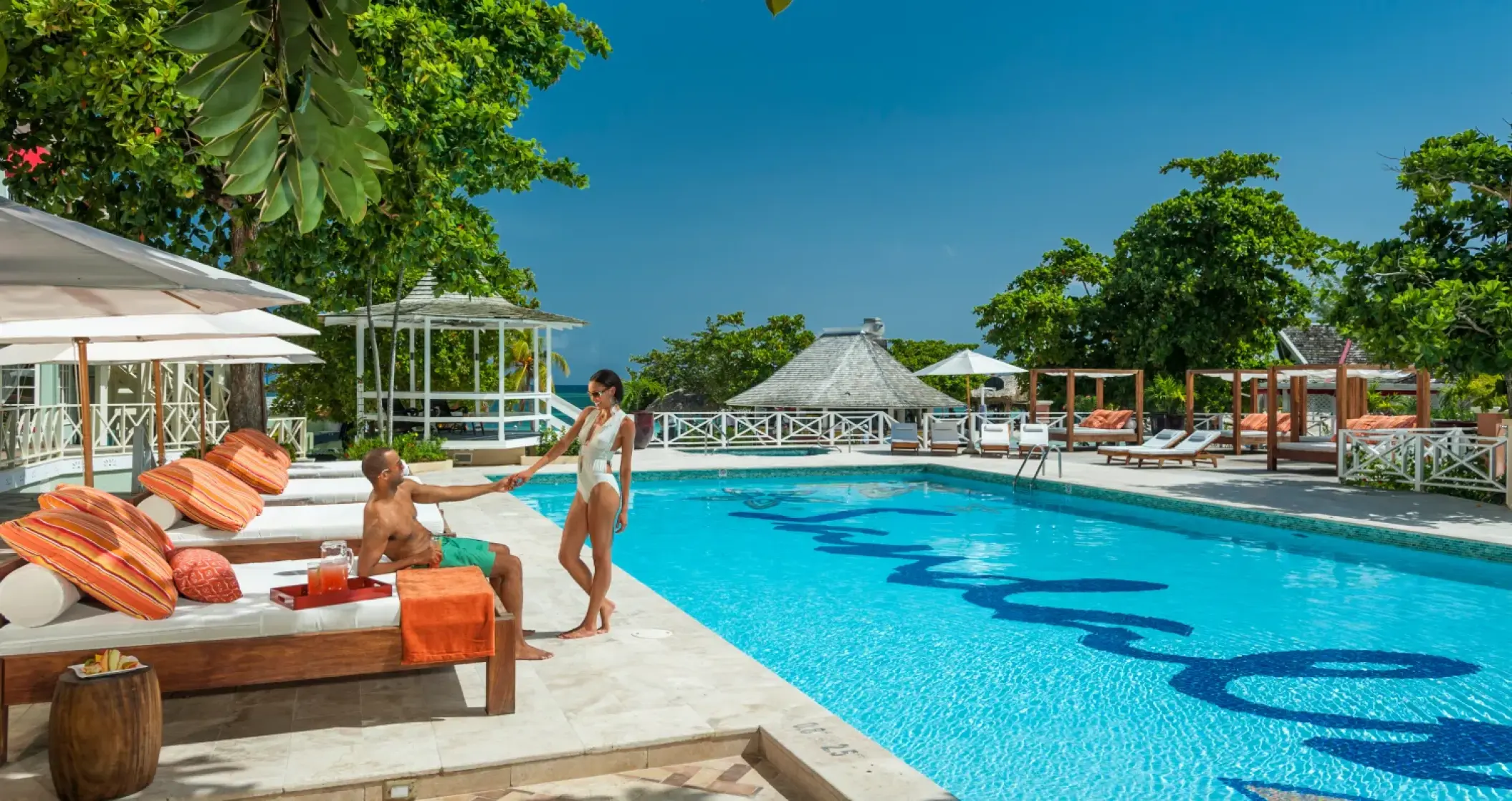Couple lounging by the main pool at Sandals Montego Bay