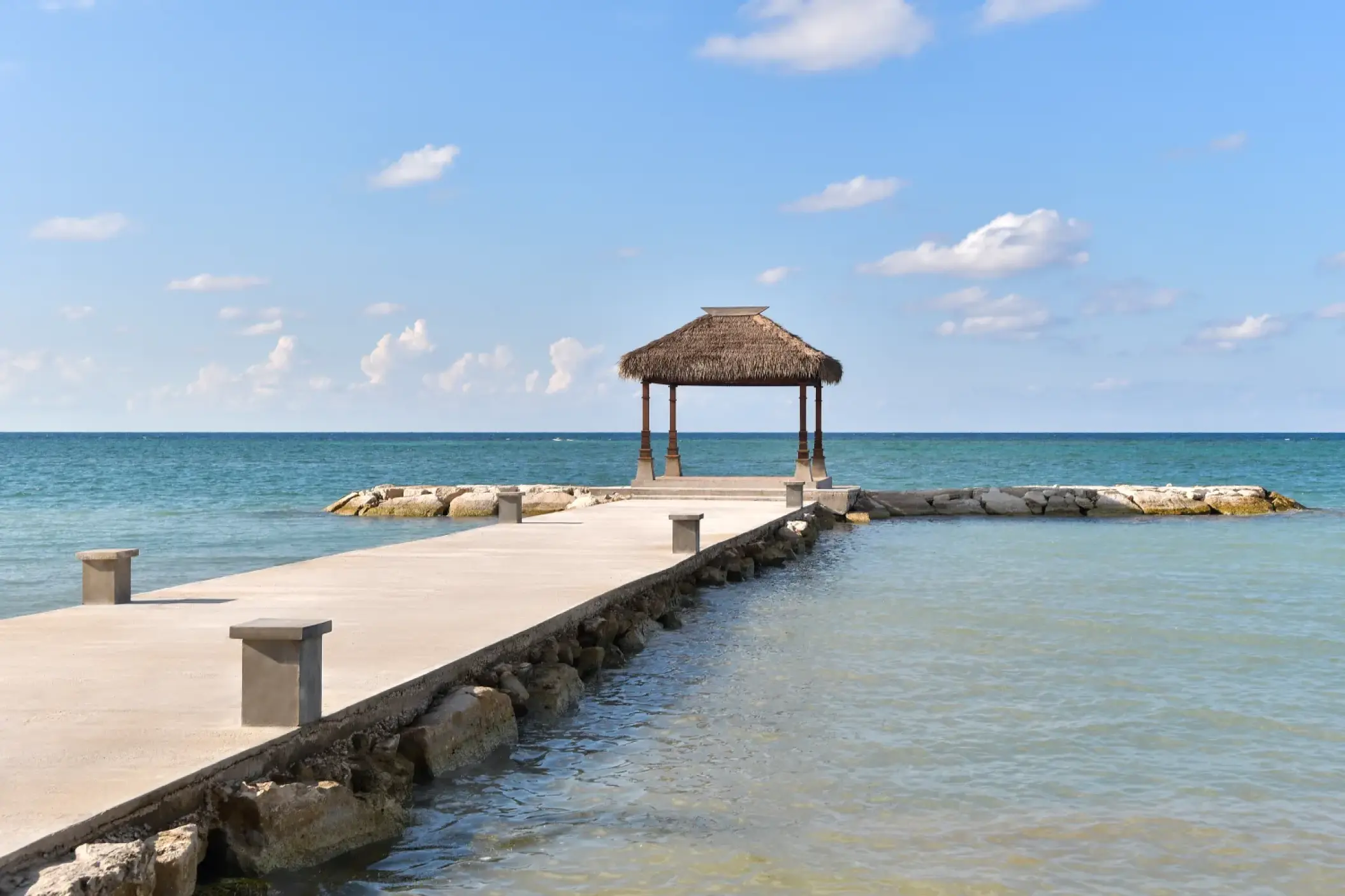 Overwater wedding gazebo at the end of a stone pier at Sandals Montego Bay