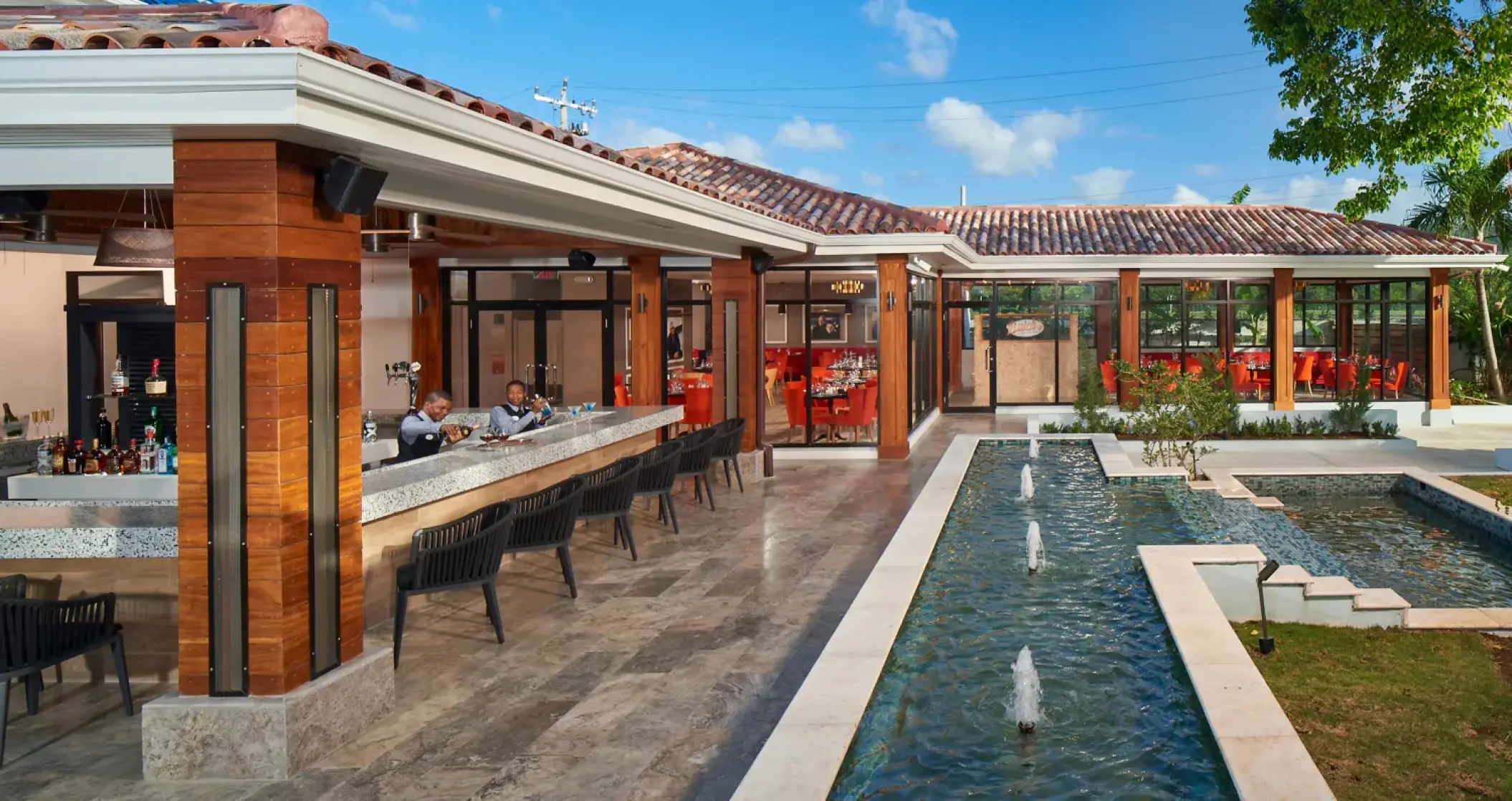 Outdoor bar and lounge area with water fountains at Sandals Montego Bay