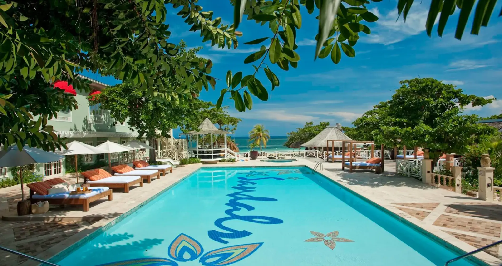 Outdoor swimming pool with sun loungers at Sandals Montego Bay, Montego Bay