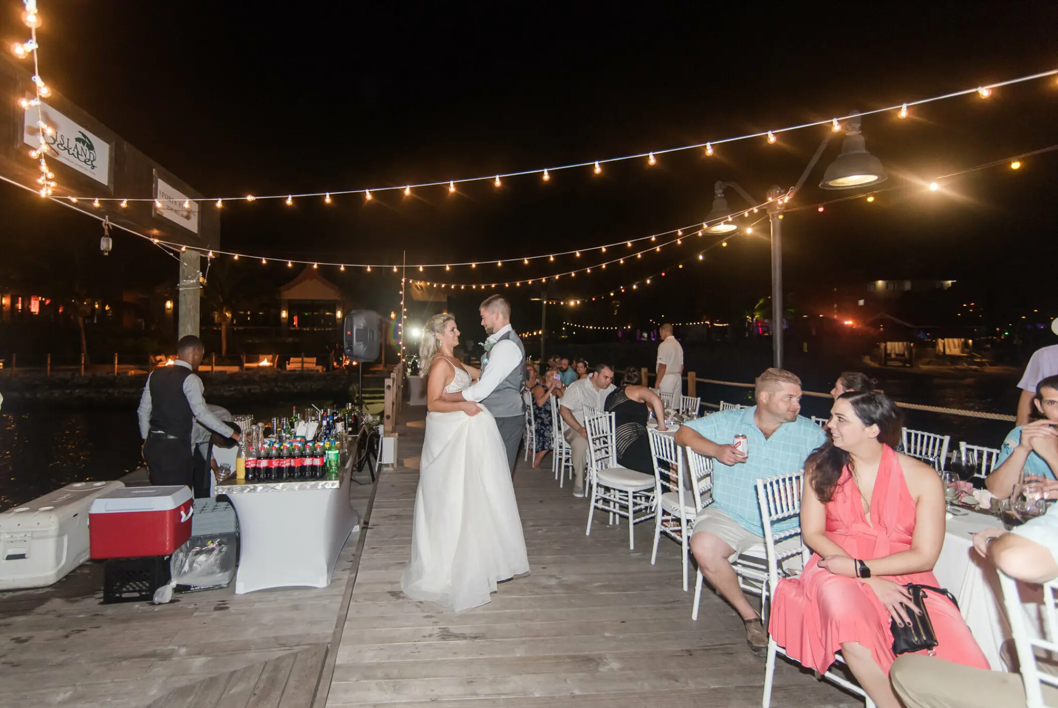 Bride and groom dancing at an outdoor reception under string lights at Sandals Ochi, Ocho Rios