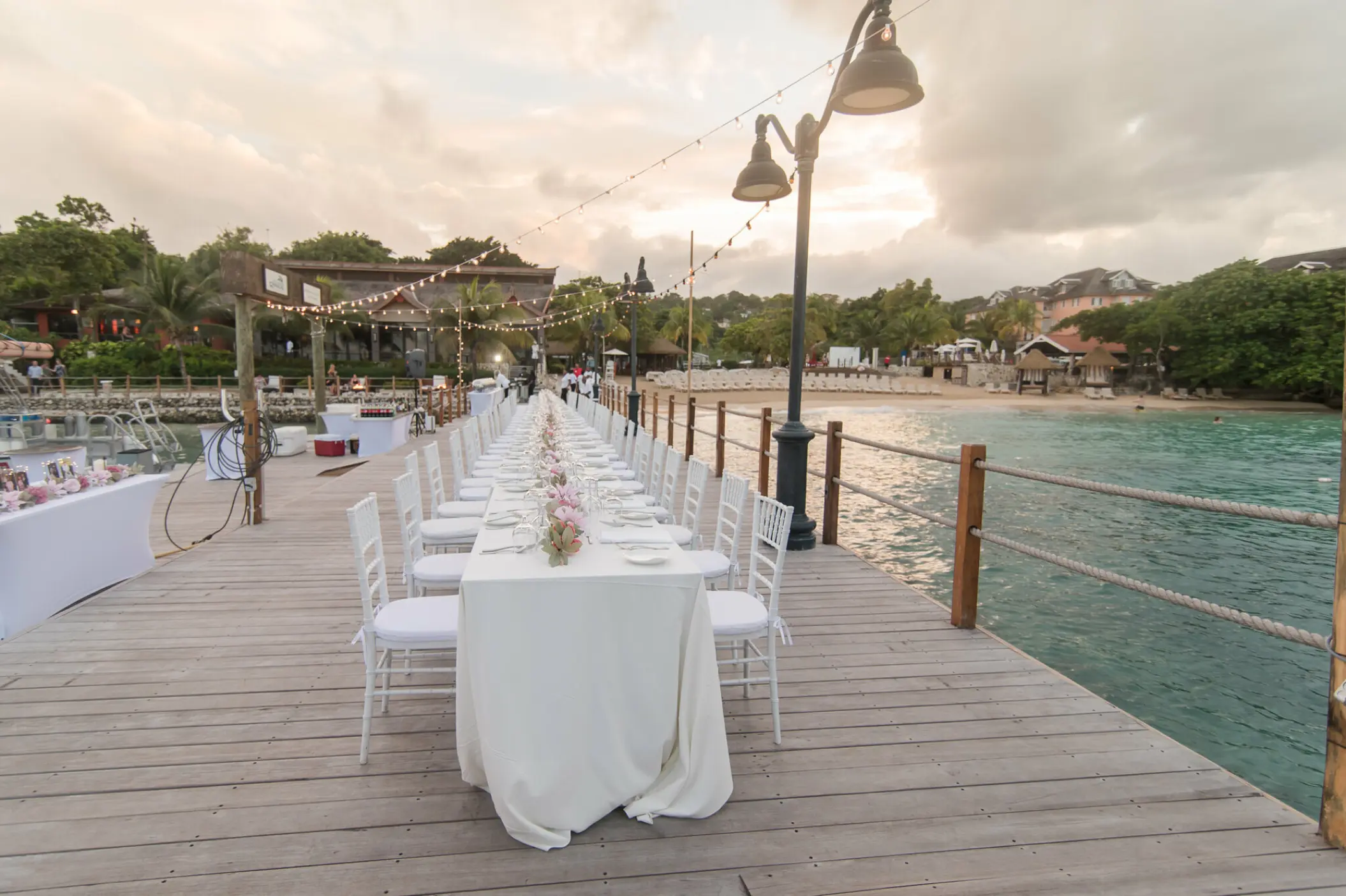 Long table wedding reception on a wooden pier at Sandals Ochi, Ocho Rios