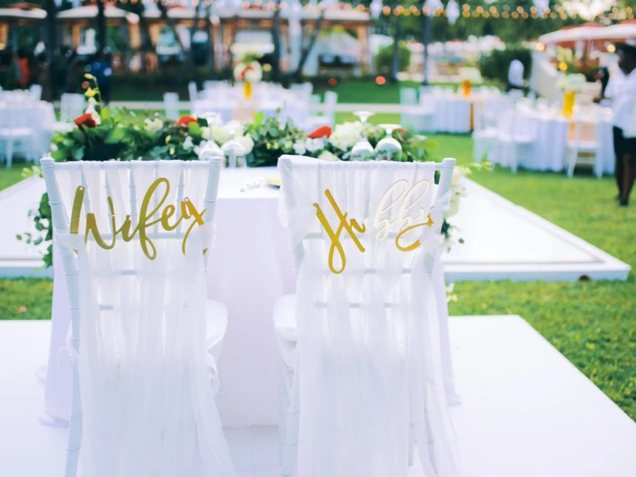 Wifey and Hubby gold signs on sweetheart chairs for a wedding reception at Sandals Ochi, Ocho Rios