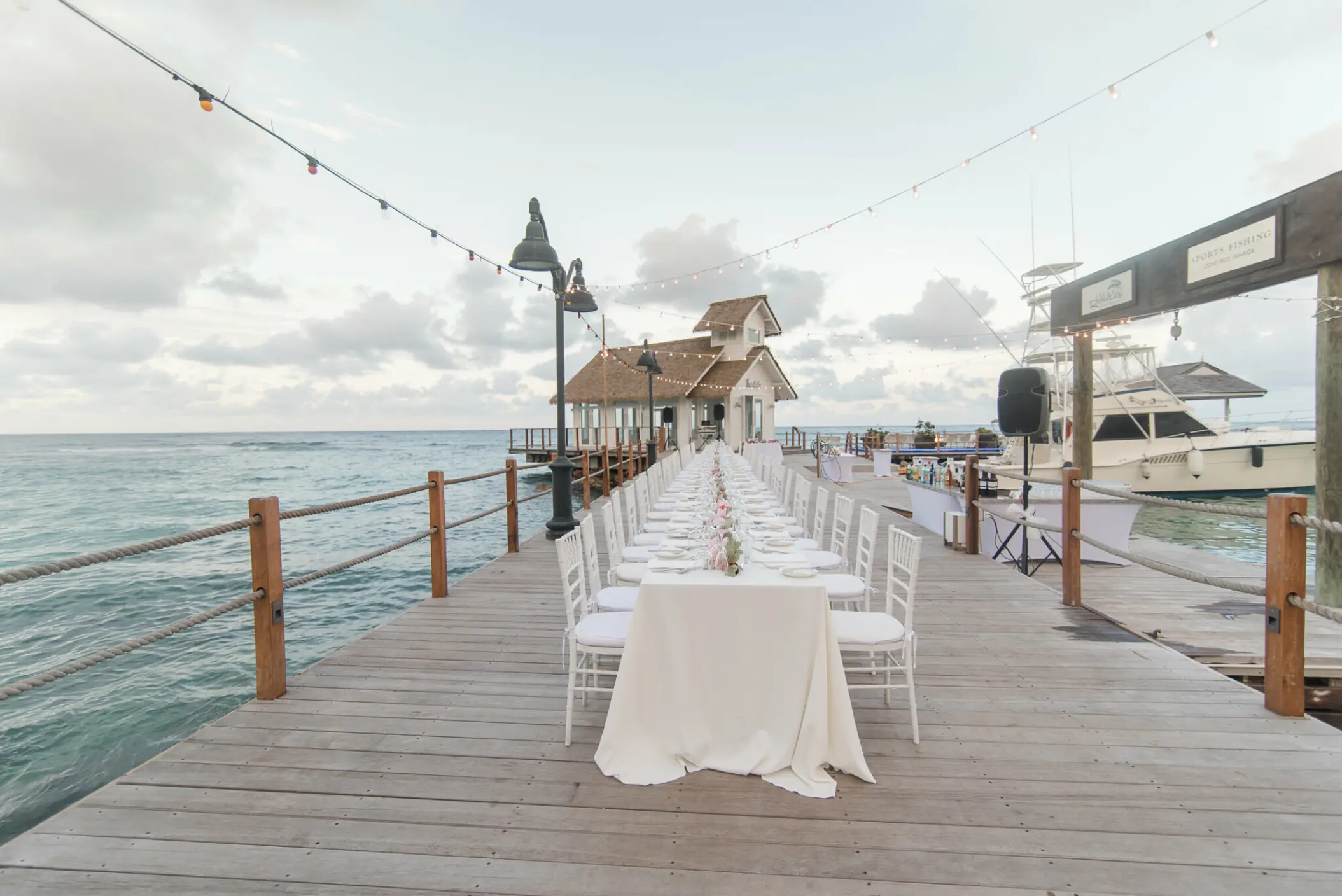 Long reception table on a wooden pier leading to the over-the-water chapel at Sandals Ochi, Ocho Rios