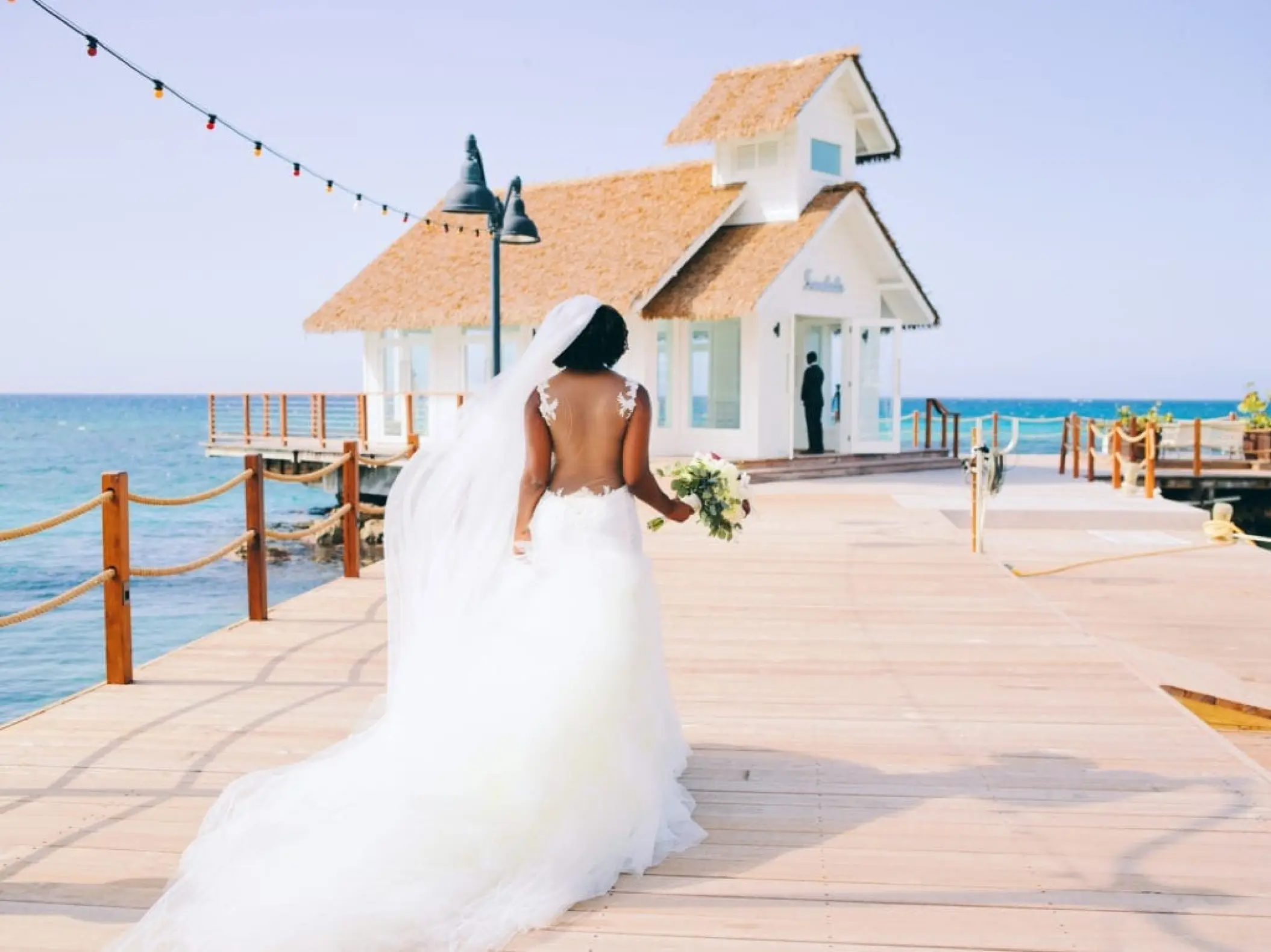 Bride walking toward the overwater wedding chapel at Sandals Ochi, Ocho Rios
