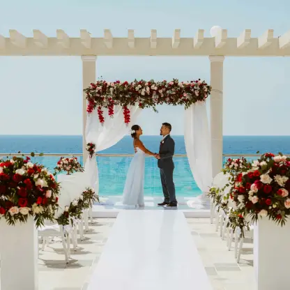 Rooftop wedding ceremony under a floral pergola at Sandos Cancun overlooking the Caribbean Sea
