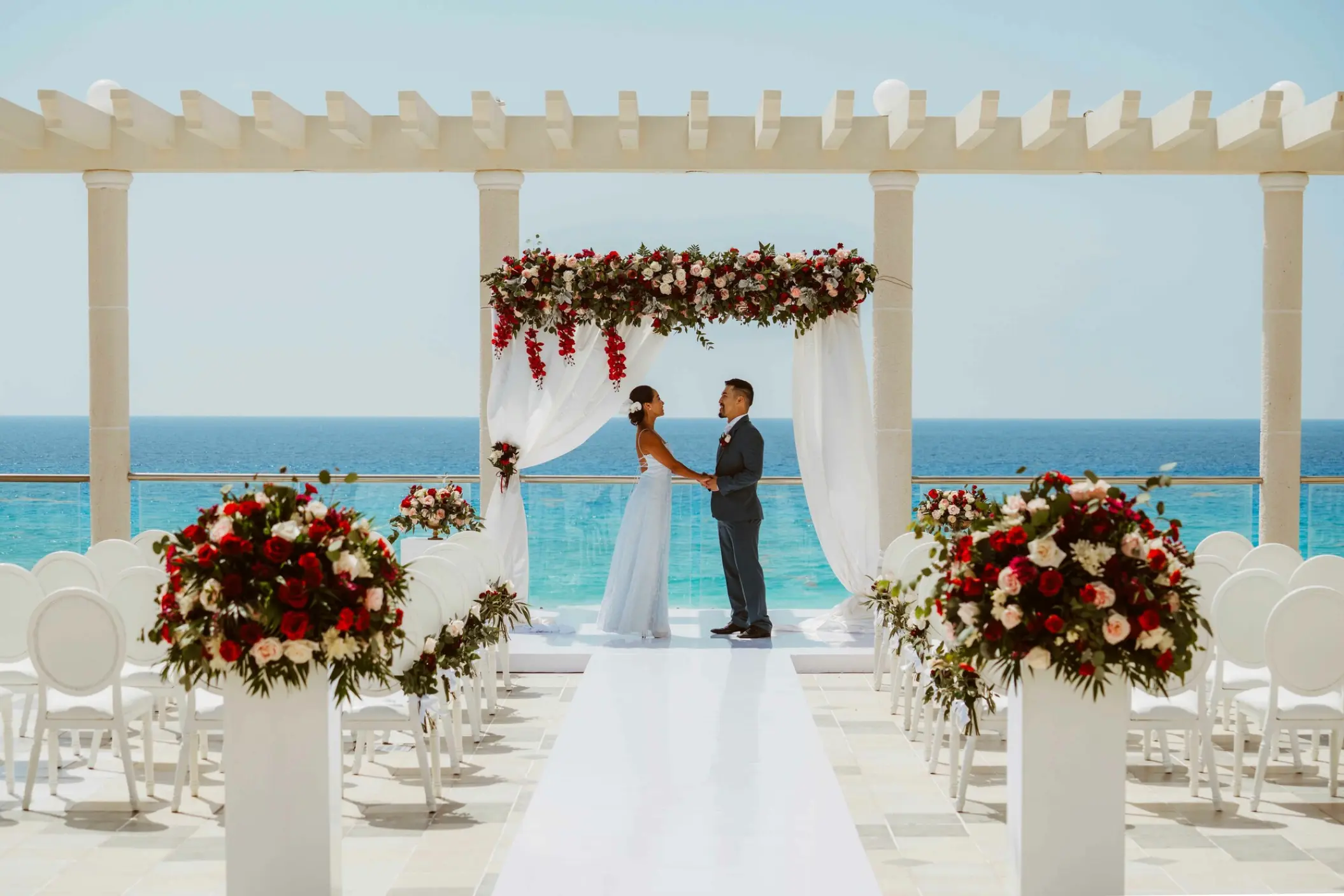Rooftop wedding ceremony under a floral pergola at Sandos Cancun overlooking the Caribbean Sea