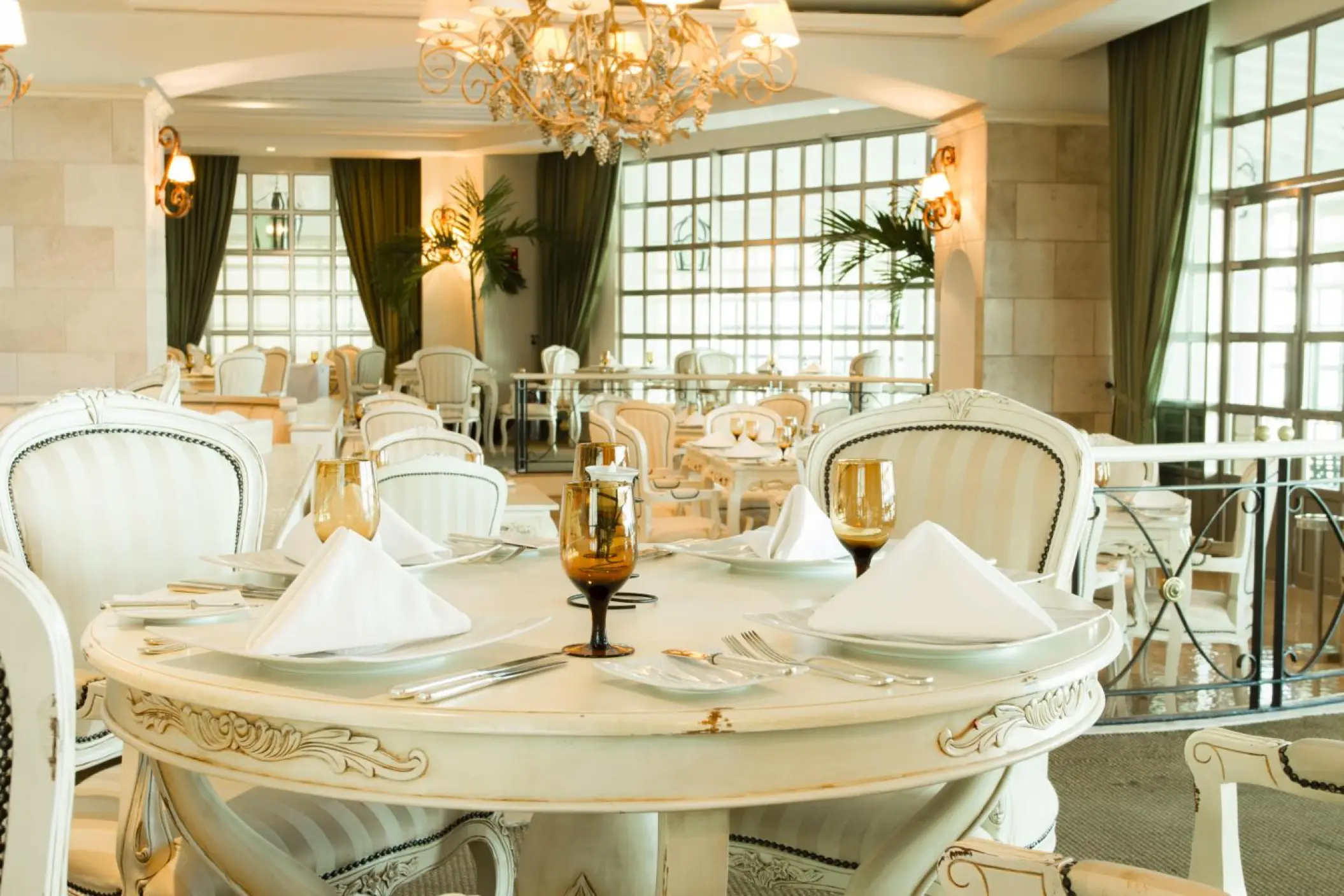 Elegant white dining room with chandeliers at Sandos Cancun