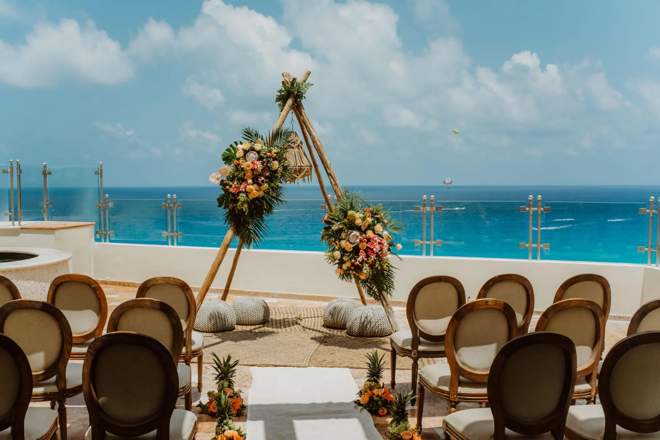 Teepee wedding ceremony arch on a terrace overlooking the ocean at Sandos Cancun, Cancun