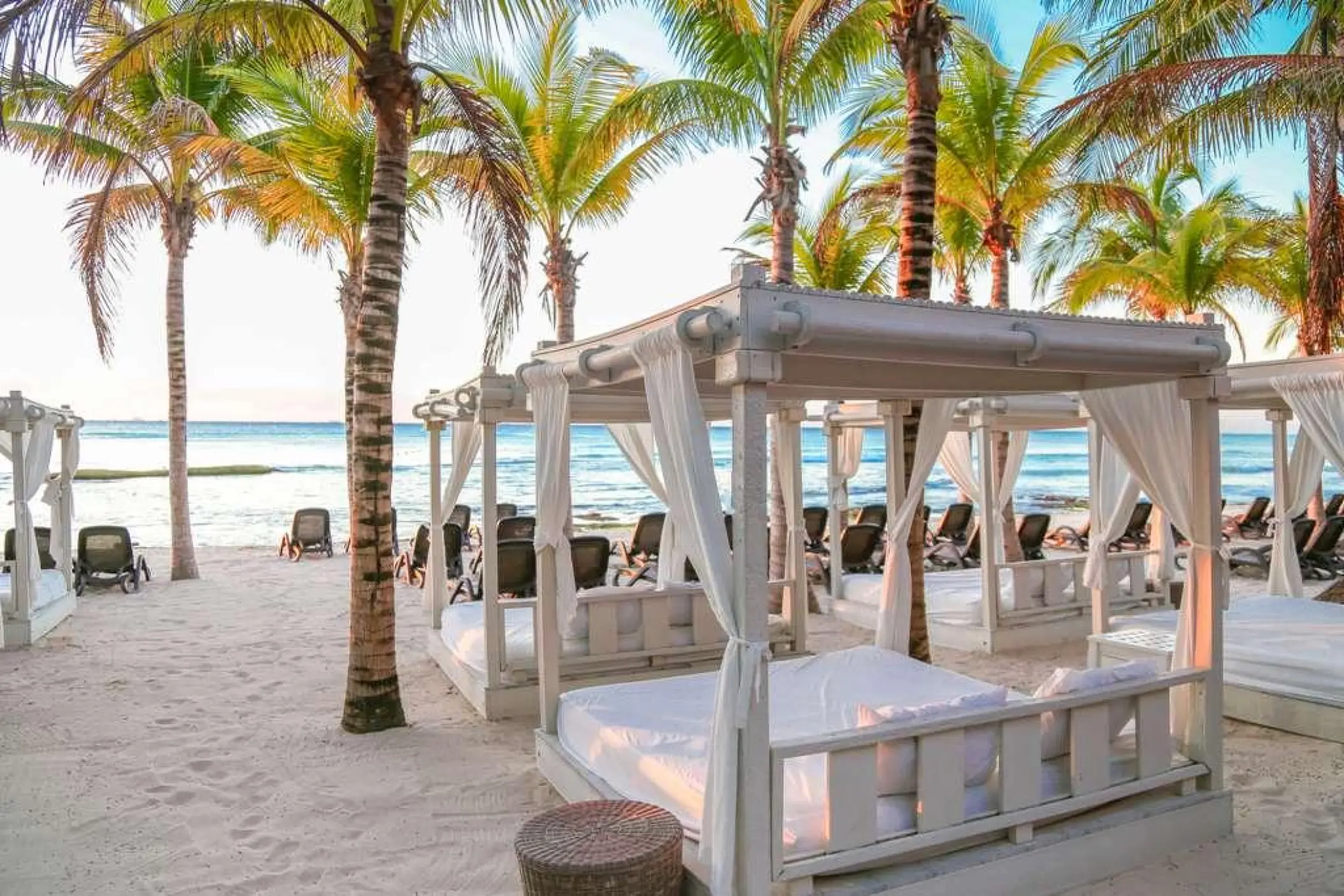 White beach cabanas under palm trees at Sandos Caracol, Playa Del Carmen