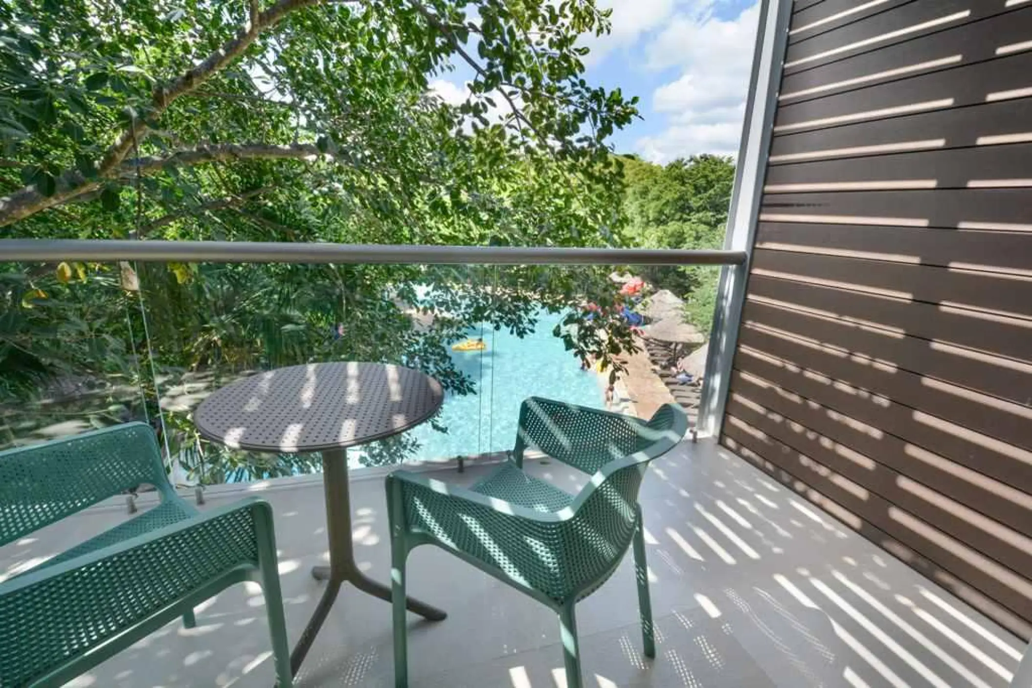 Penthouse terrace overlooking a pool and lush trees at Sandos Caracol, Playa Del Carmen