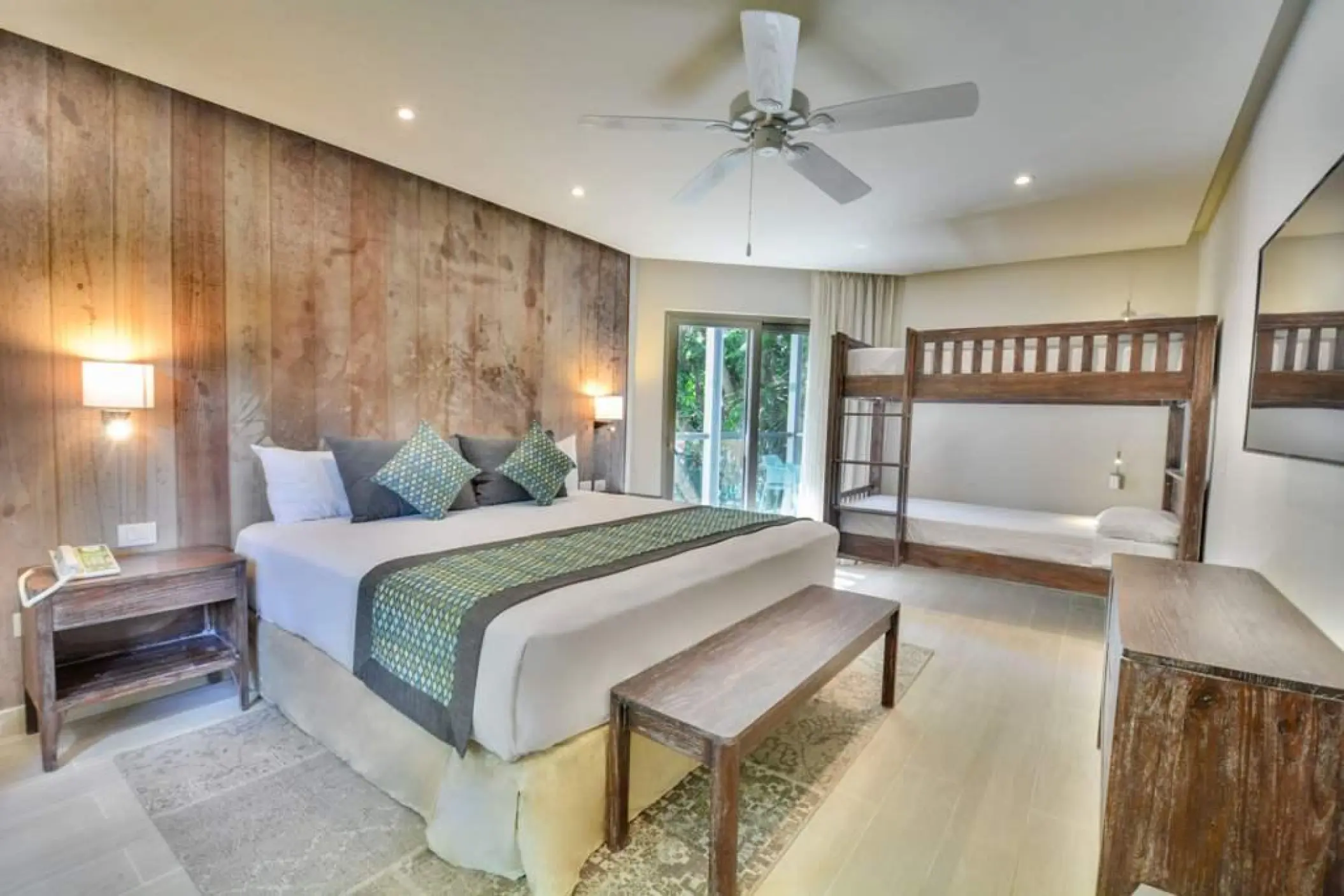 Superior family room with a king bed and wooden bunk beds at Sandos Caracol, Playa Del Carmen