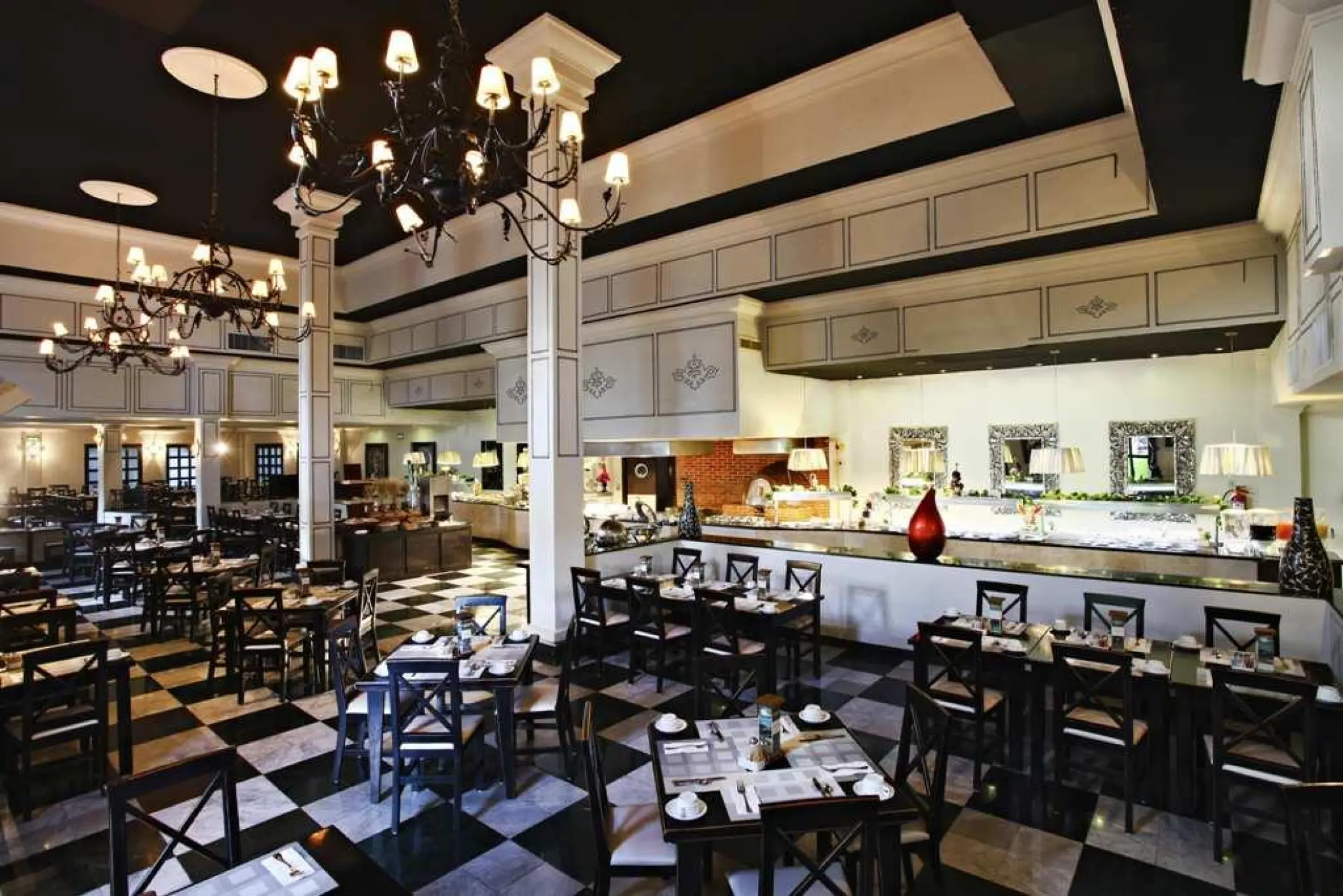 Toscana restaurant interior with checkered floors and chandeliers at Sandos Caracol, Playa Del Carmen