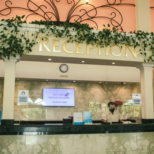 Reception desk with hanging vines and decorative metalwork at Sandos Playacar, Playa Del Carmen