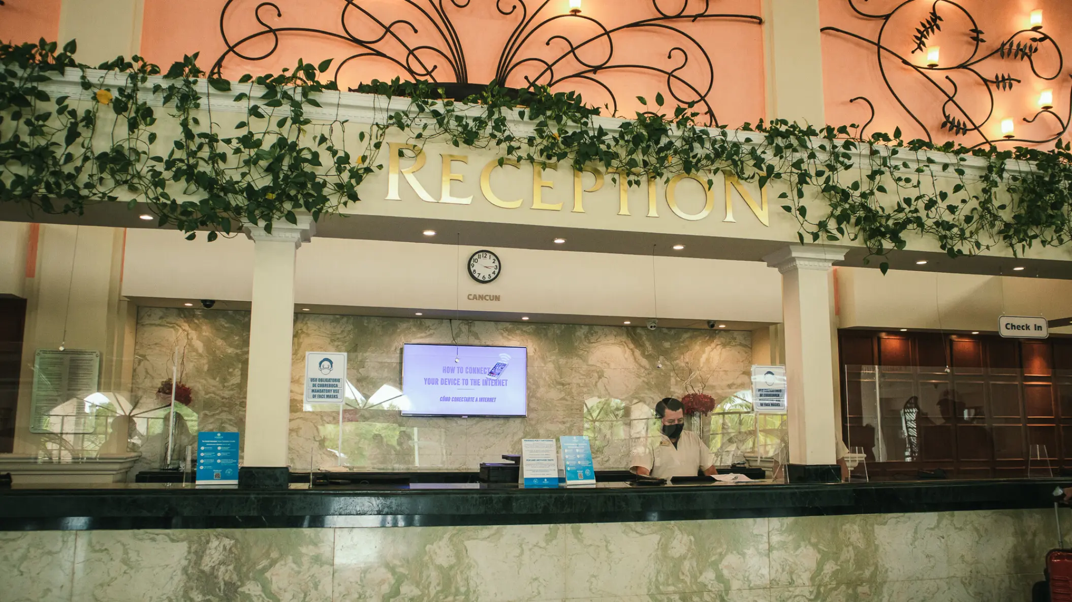 Reception desk with hanging vines and decorative metalwork at Sandos Playacar, Playa Del Carmen