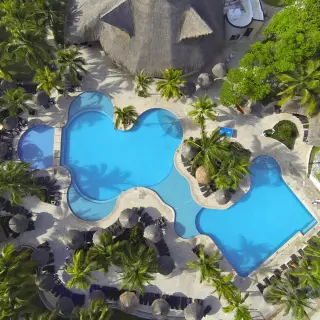 Aerial view of the winding blue swimming pools and palm trees at Sandos Playacar, Playa Del Carmen