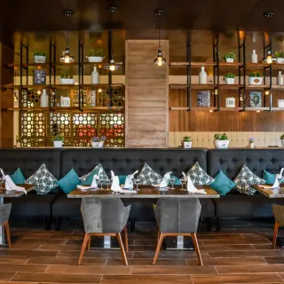 Indoor dining room with long tufted booth seating and wooden accents at Sandos Playacar, Playa Del Carmen