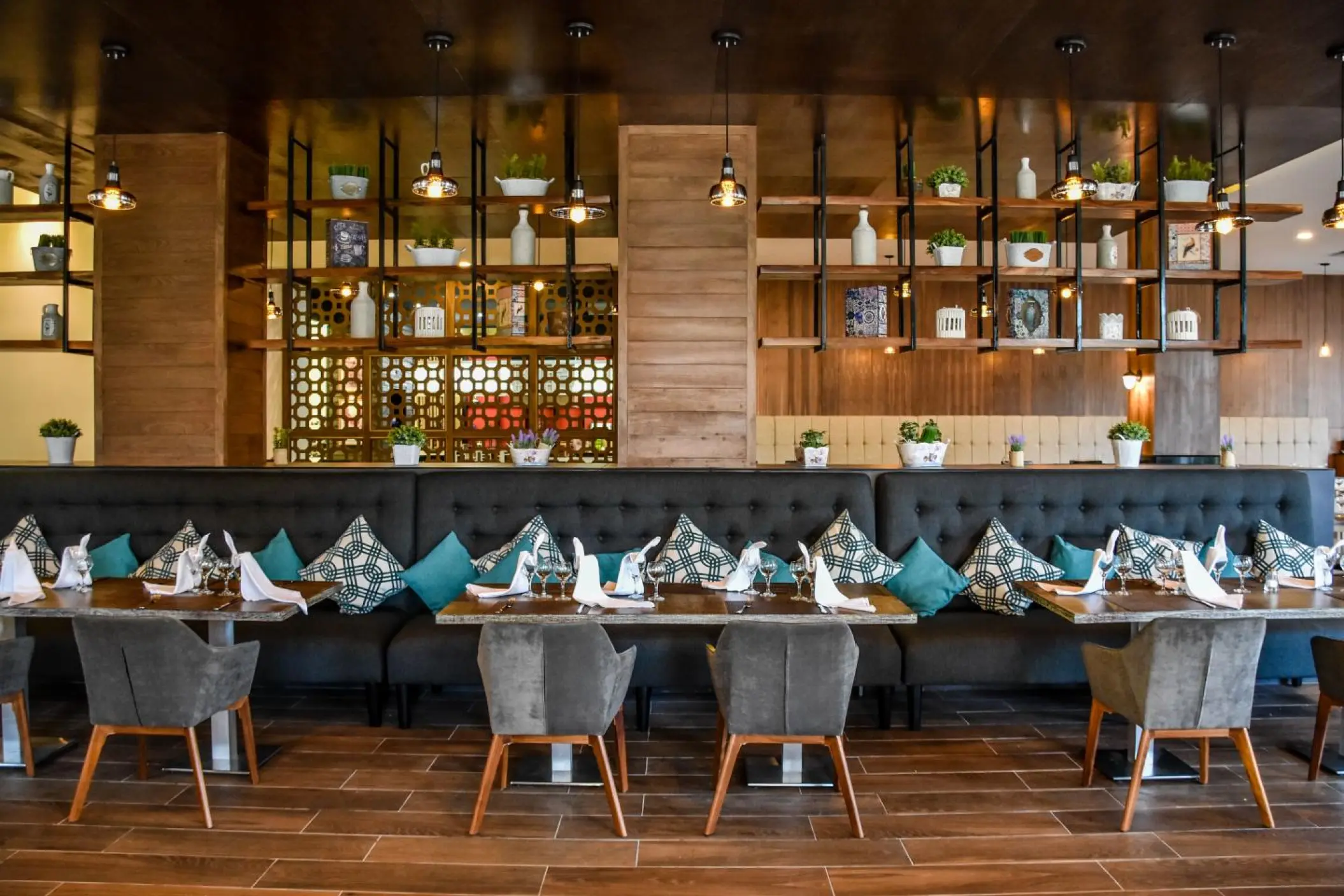 Indoor dining room with long tufted booth seating and wooden accents at Sandos Playacar, Playa Del Carmen