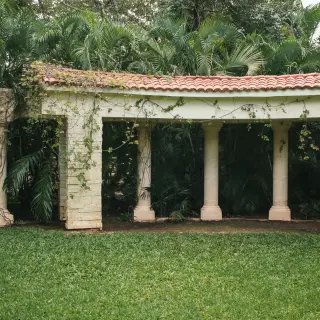 Secret Garden wedding venue with stone columns and lush greenery at Sandos Playacar, Playa Del Carmen