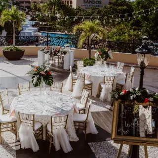 Terrace wedding reception with floral centerpieces and white linens at Sandos Playacar, Playa Del Carmen