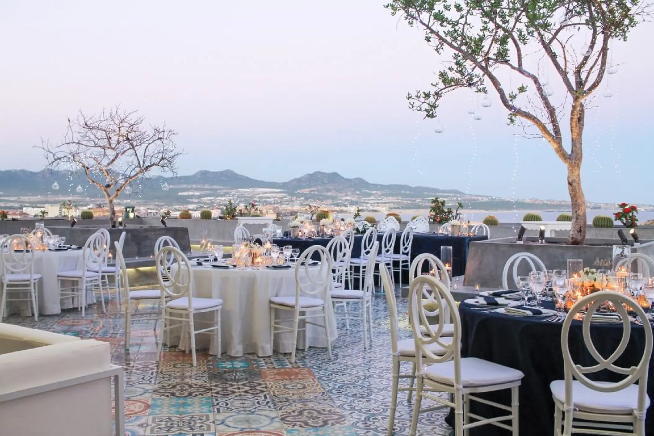 Terrace wedding reception with white and navy tables at Sandos Finisterra, Cabo San Lucas