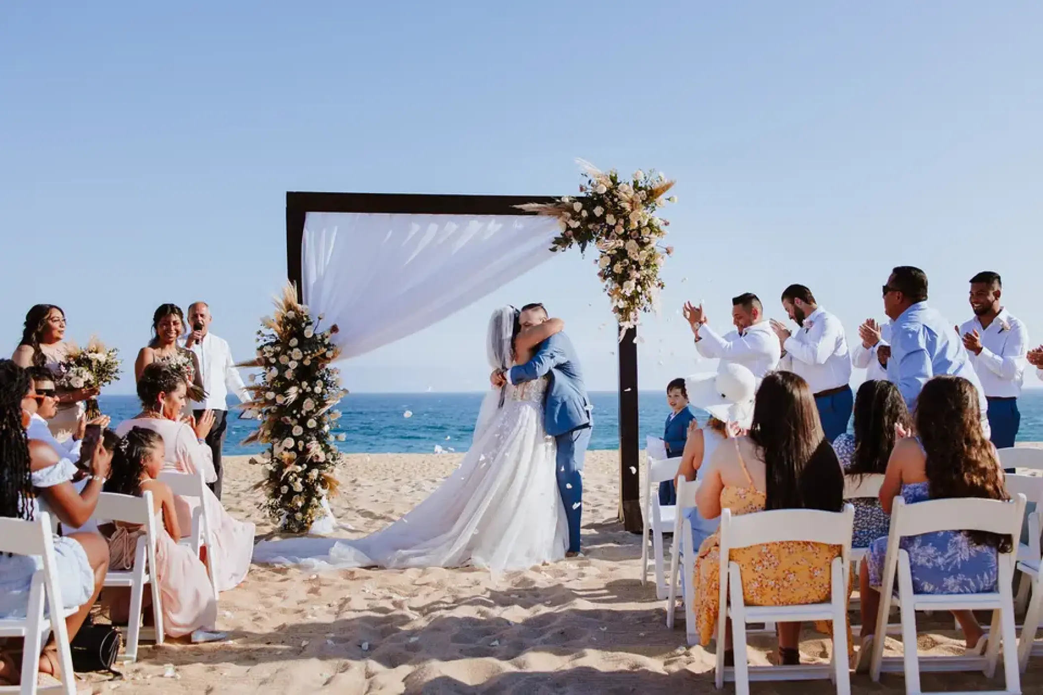 Bride and groom embracing at a beach ceremony at Sandos Finisterra, Cabo San Lucas