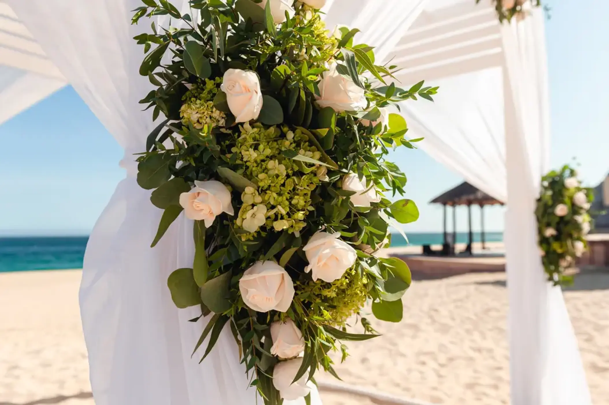 White rose floral arrangement on a beach ceremony gazebo at Sandos Finisterra, Cabo San Lucas