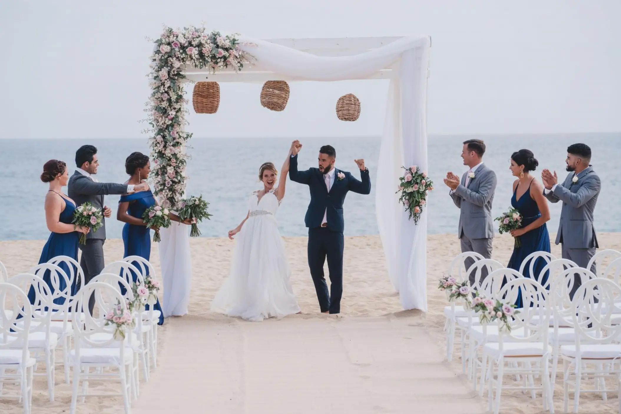 The couple celebrating at a beach ceremony at Sandos Finisterra, Cabo San Lucas
