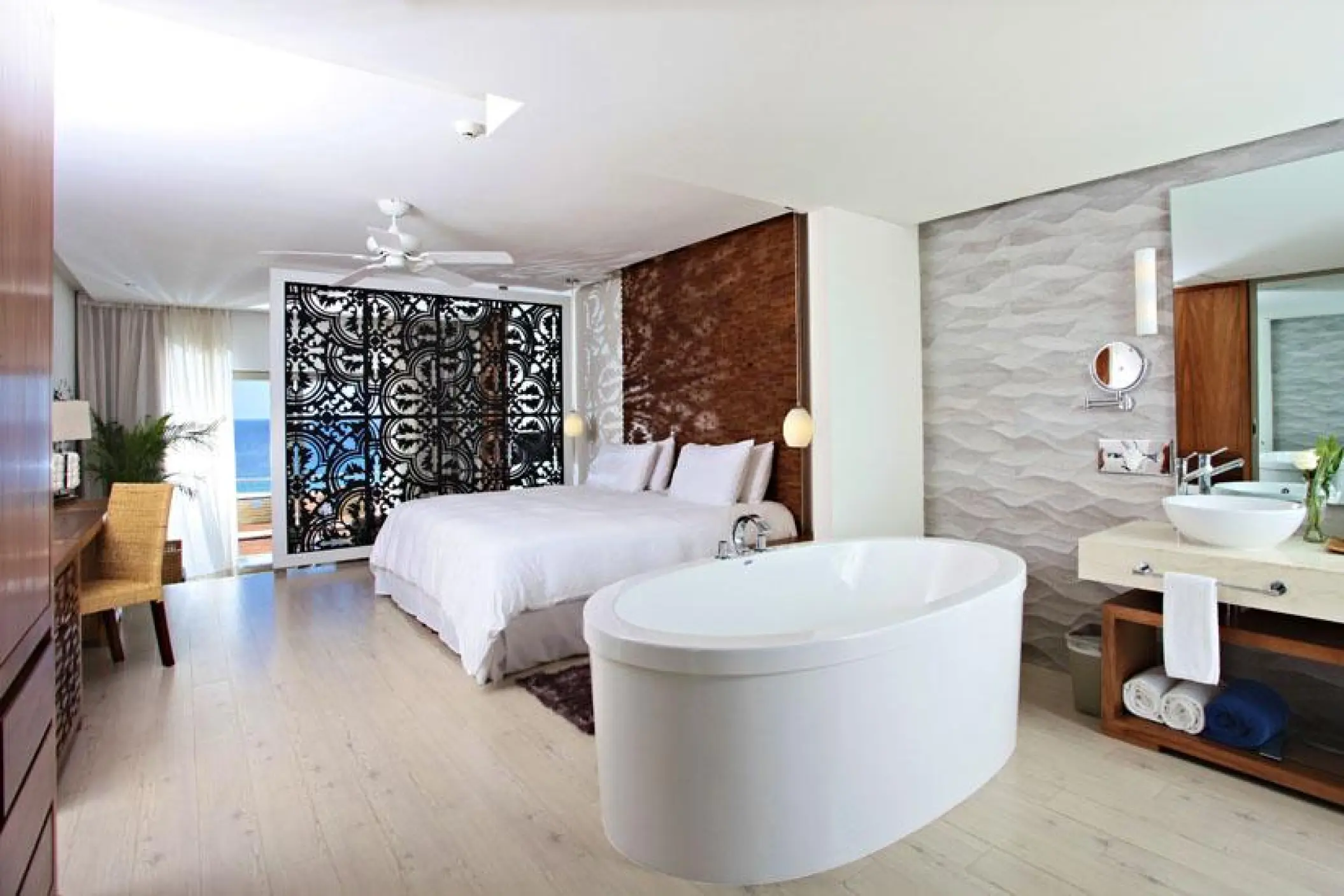 Junior suite with a white soaking tub and private balcony at Sandos Finisterra, Cabo San Lucas