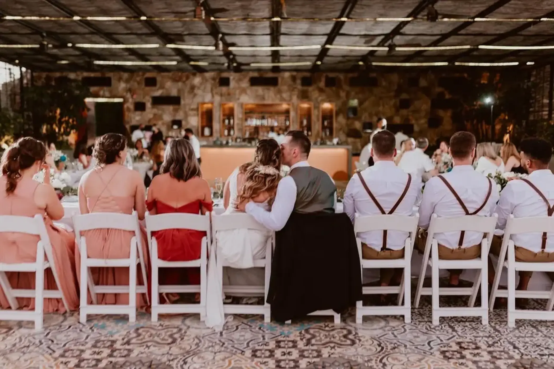 The couple and bridal party seated at a terrace wedding reception at Sandos Finisterra, Cabo San Lucas