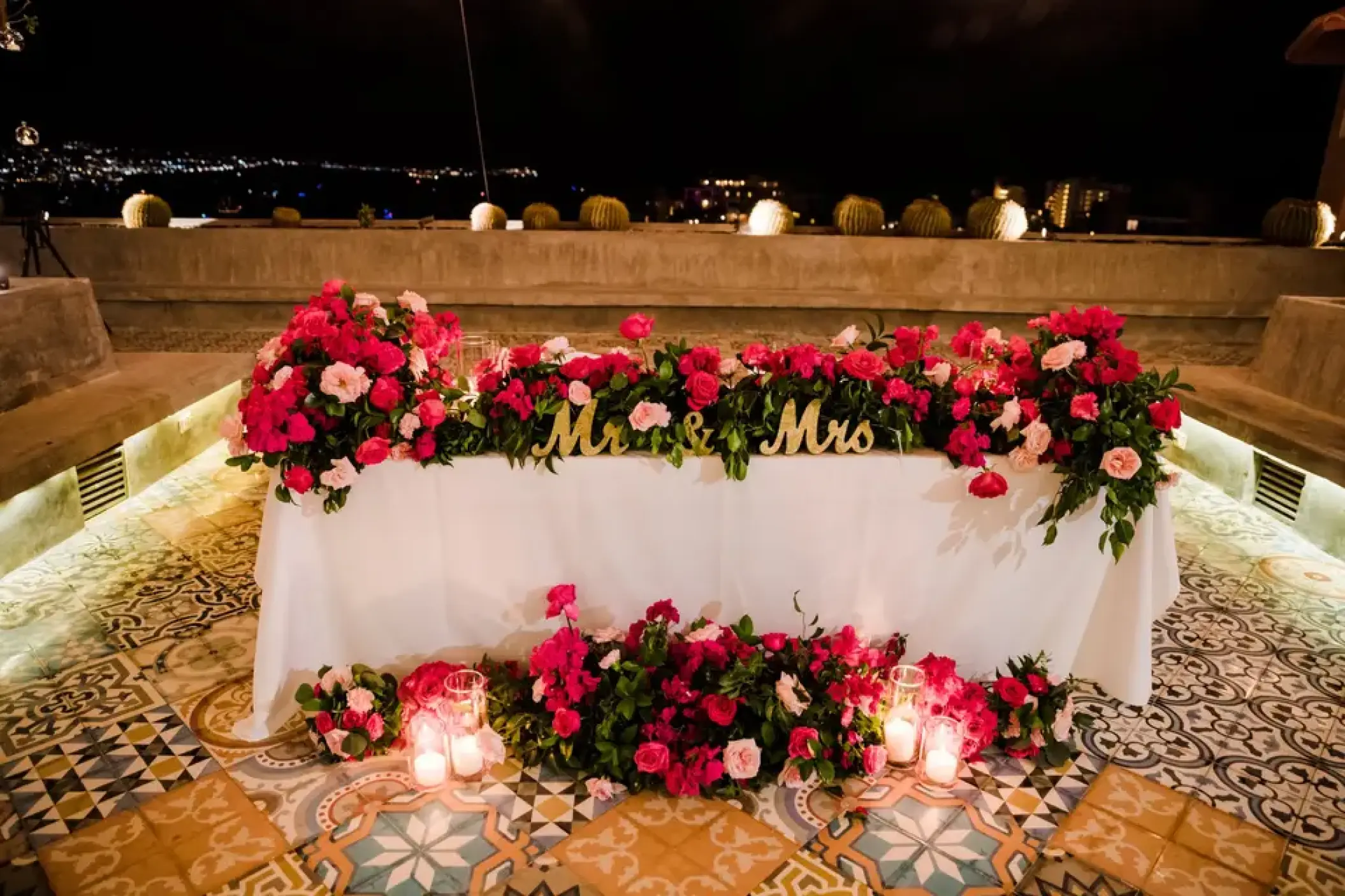 Sweetheart table with pink floral arrangements and Mr & Mrs sign at Sandos Finisterra, Cabo San Lucas